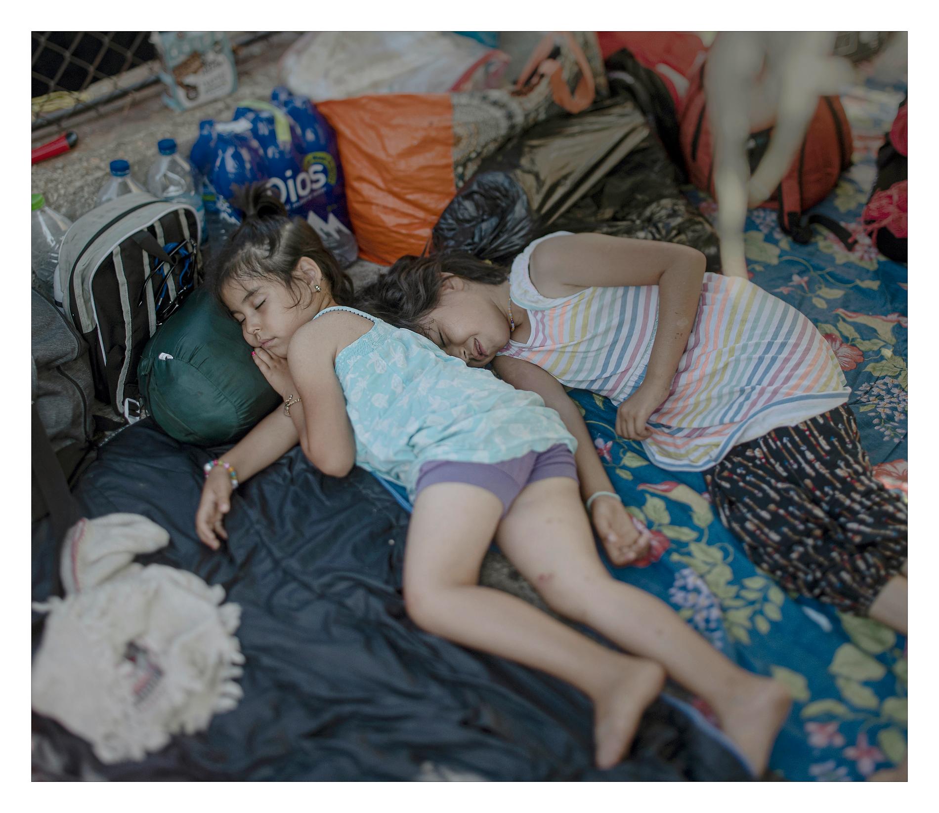De afghanska systrarna Ghazal, 6 och Azal, 8 ligger orörliga under en filt. De är sjuka av sorg sedan deras mamma dog hemma i Iran, berättar fastern.