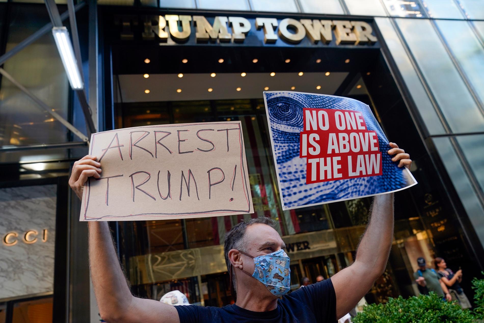 En demonstrant utanför Trump Tower i New York på tisdagen kräver att ex-presidenten ska gripas. Även anhängare till presidenten fanns på plats.