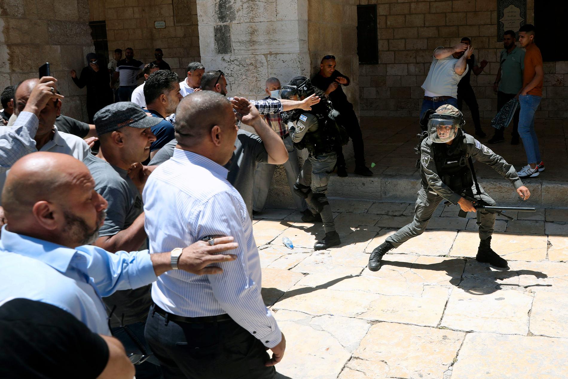 Israelisk gränspolis svingar batongen i närheten av Al-Aqsa moskén på fredagen. 