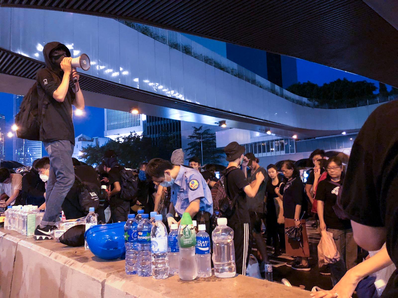 Demonstranter bunkrar vatten och produkter för att tvätta ögonen rena från tårgas.