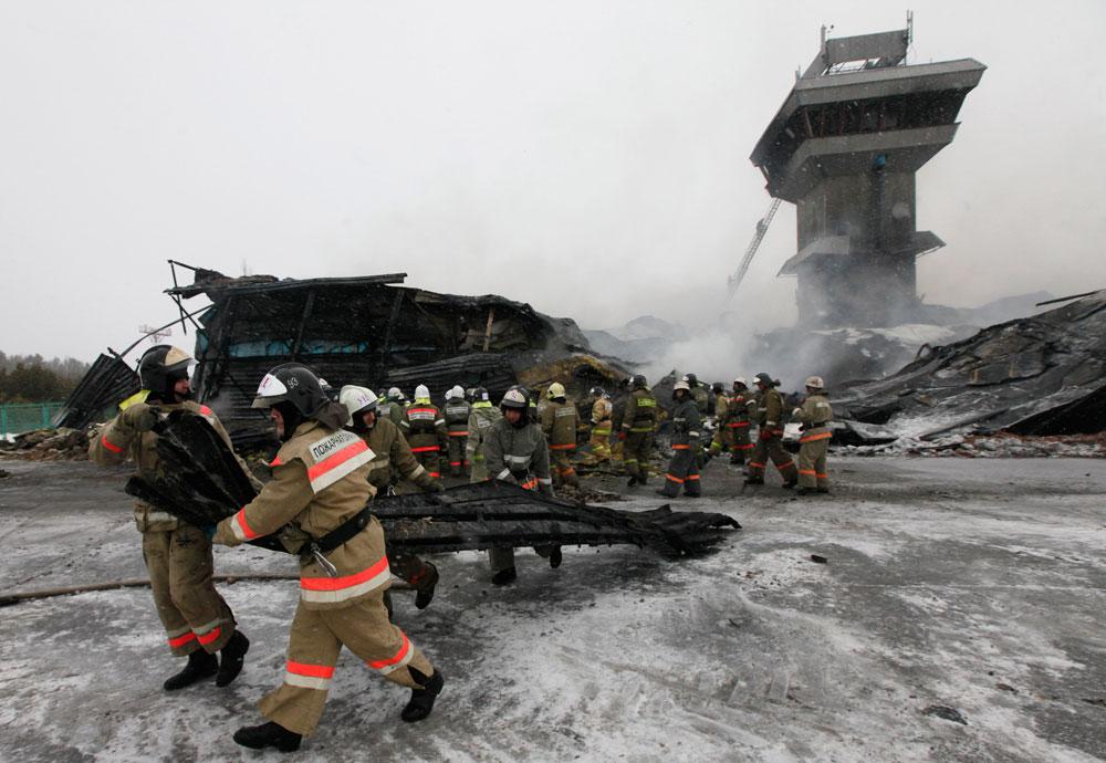 Räddningsarbetare jobbar efter den stora branden på en rysk flygplats, 35 kilometer utanför staden Krasnojarsk.