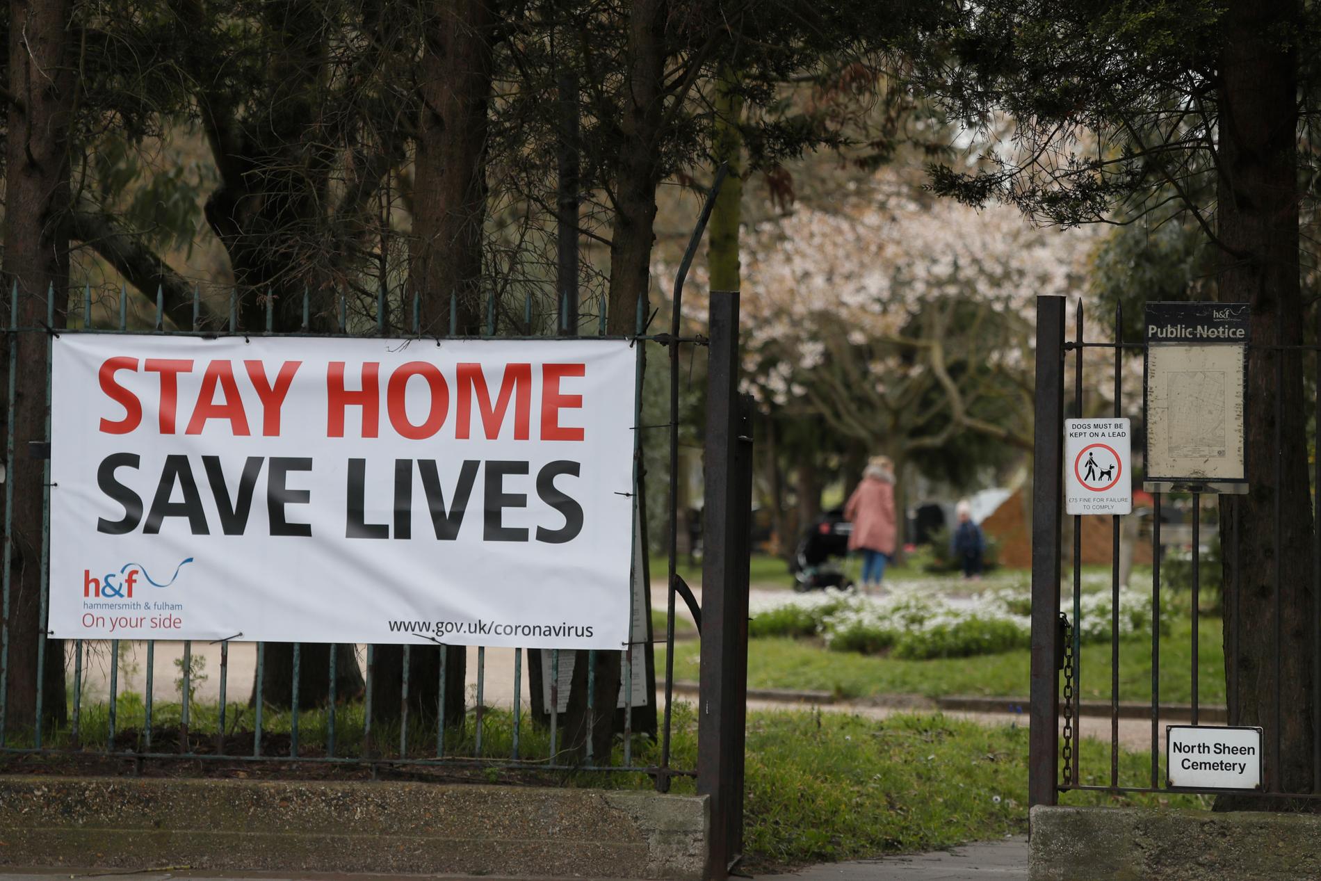En stor skylt med ett tydligt budskap – stanna hemma, rädda liv – vid en park i London.