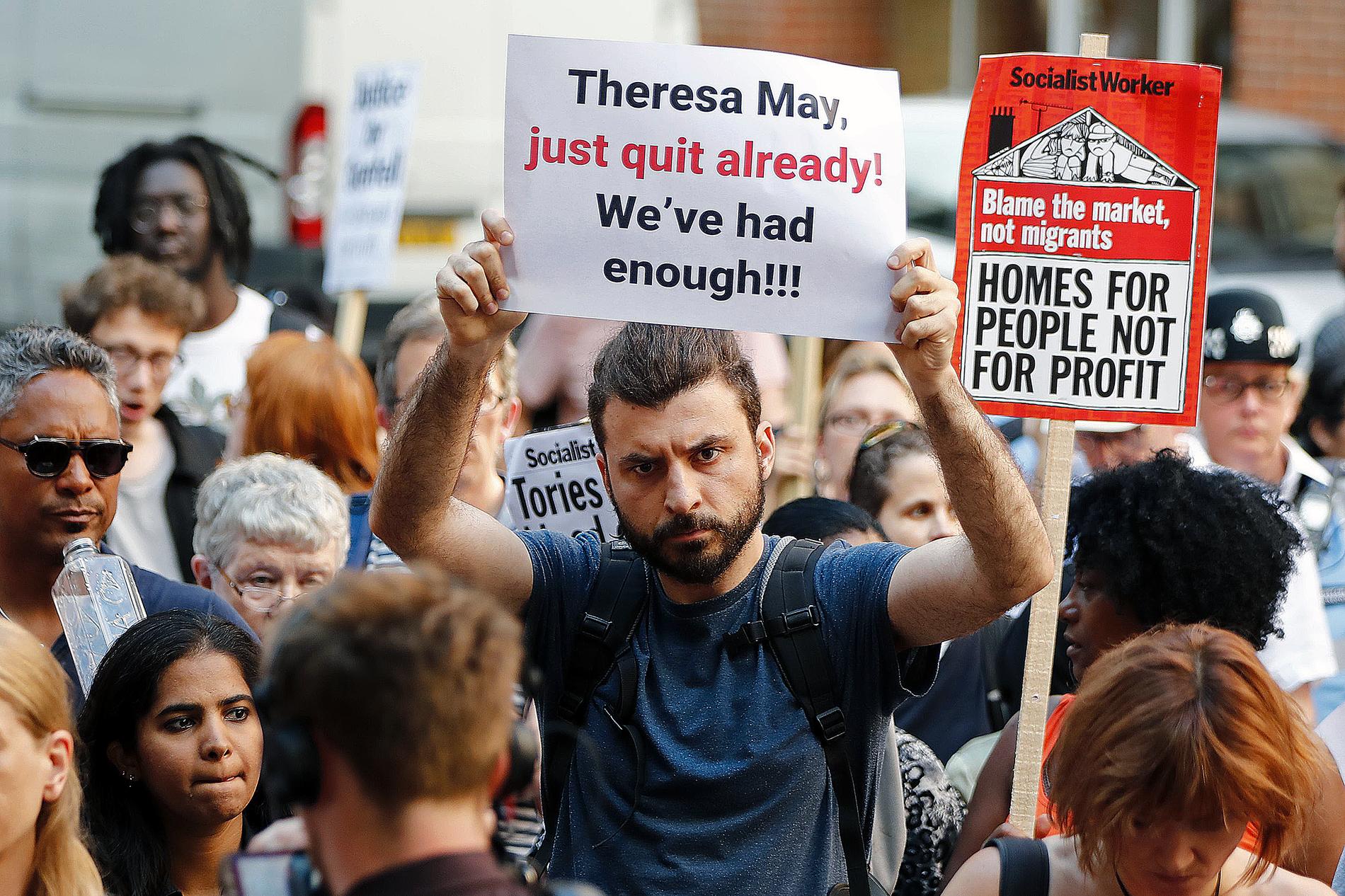 Efter sorgen kom ilskan. En man kräver Theresa Mays avgång på en demonstration efter branden i London.
