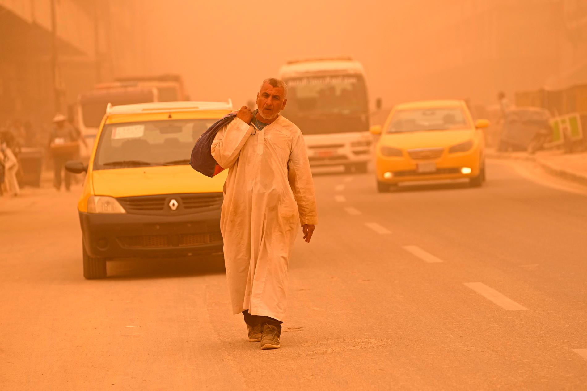 En man går längs en gata i Bagdad under en sandstorm i mitten av maj.