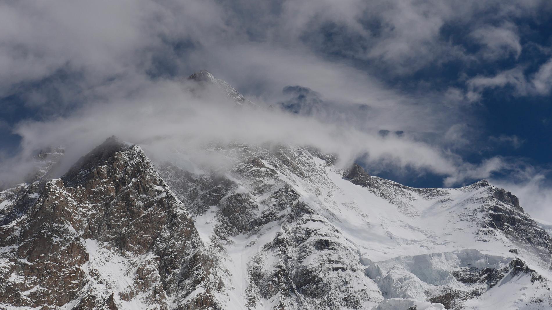 Kraftiga vindar på toppen av K2 i Pakistan ommöjliggör  klättring på det branta berget.