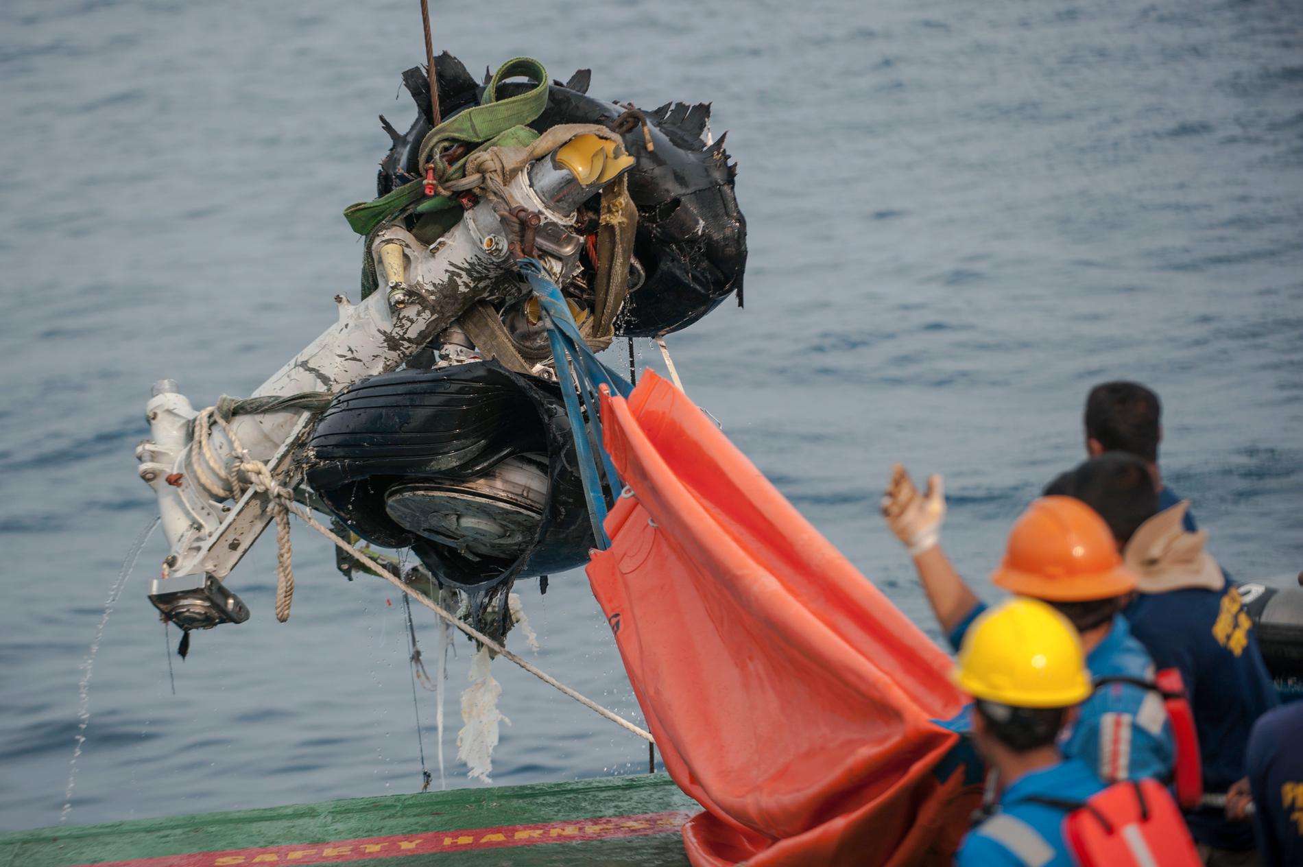 Räddningsarbetare lyfter upp delar av det kraschade Lion Air-planet ur havet.