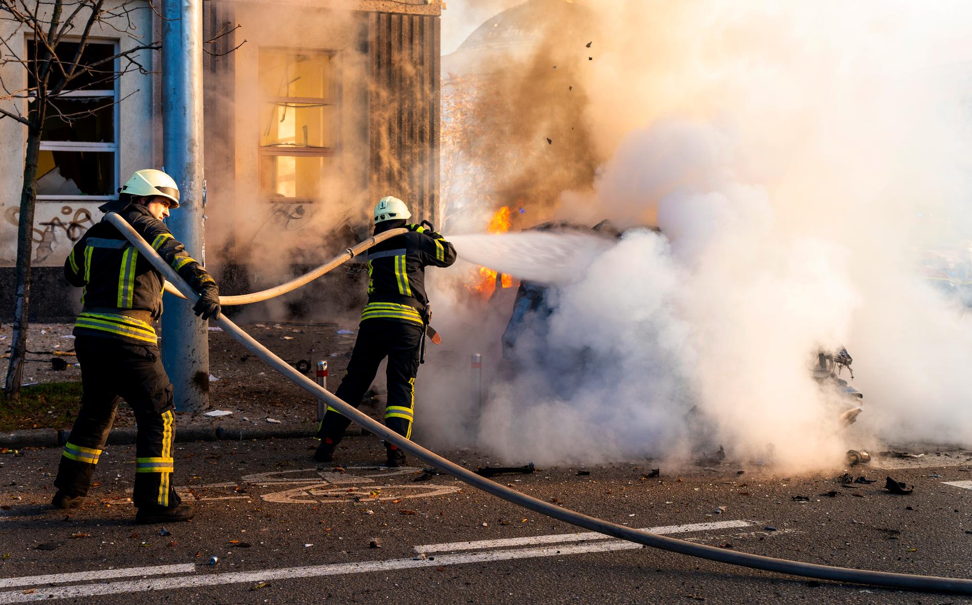 Brandmän försöker släcka en brinnande bil efter en rysk attack i Kiev på måndagen. 