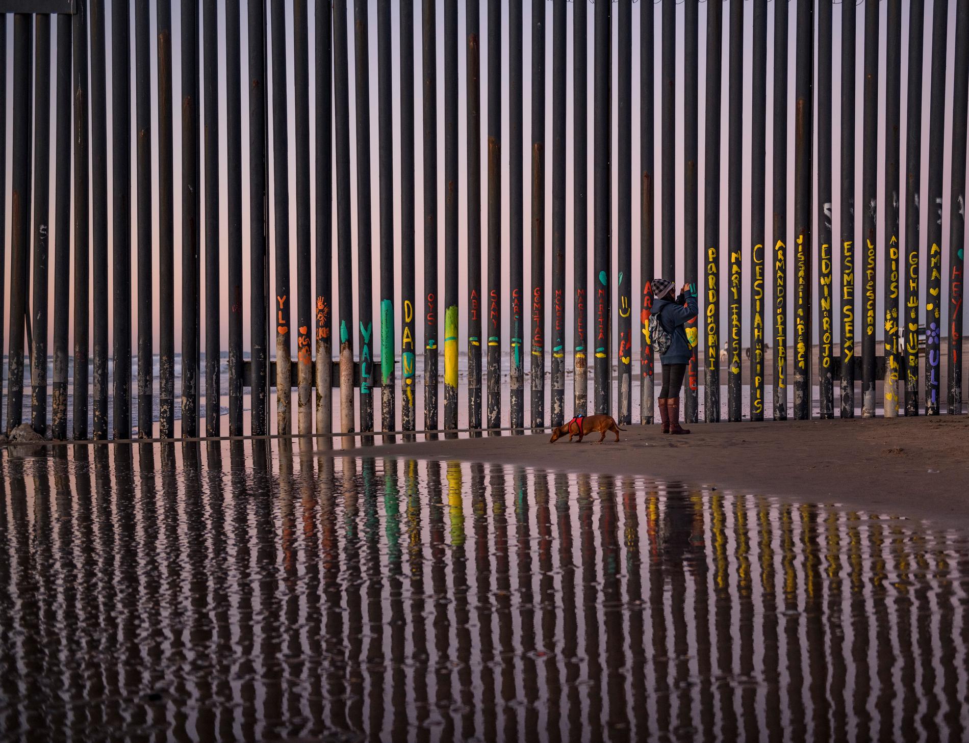 En kvinna tar en bild av gränsstängslet mellan San Diego i Kalifornien, USA, och Tijuana i Mexiko. Arkivbild.