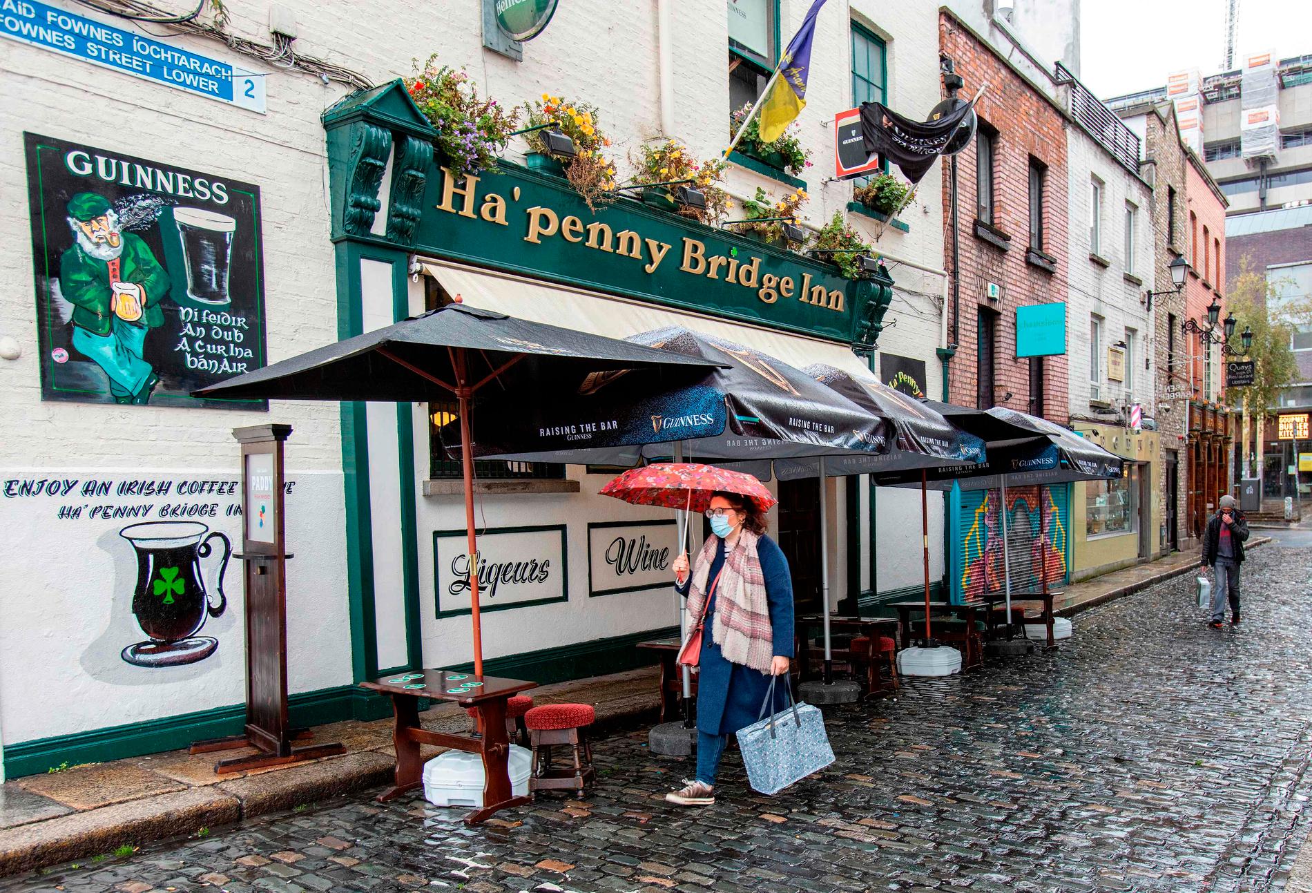 En kvinna passerar en nedstängd pub i Irlands huvudstad Dublin på måndagen.