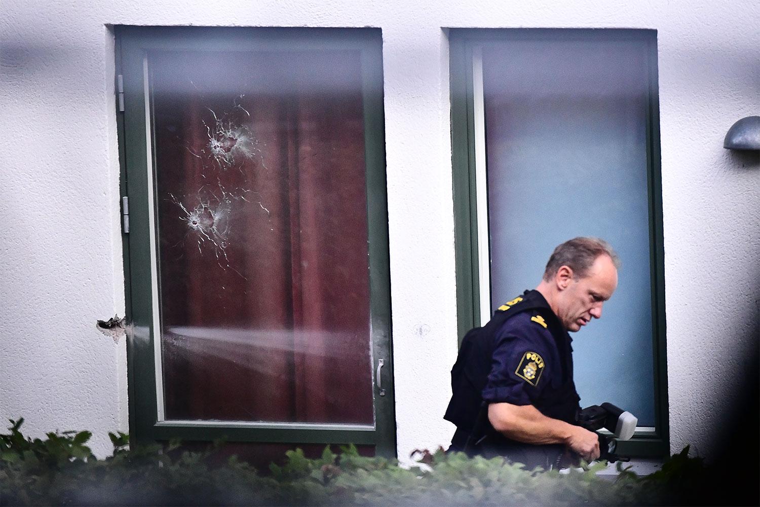 Skotthål i fönstret efter skjutningen i Råcksta där en 18-årig kvinna dog.
