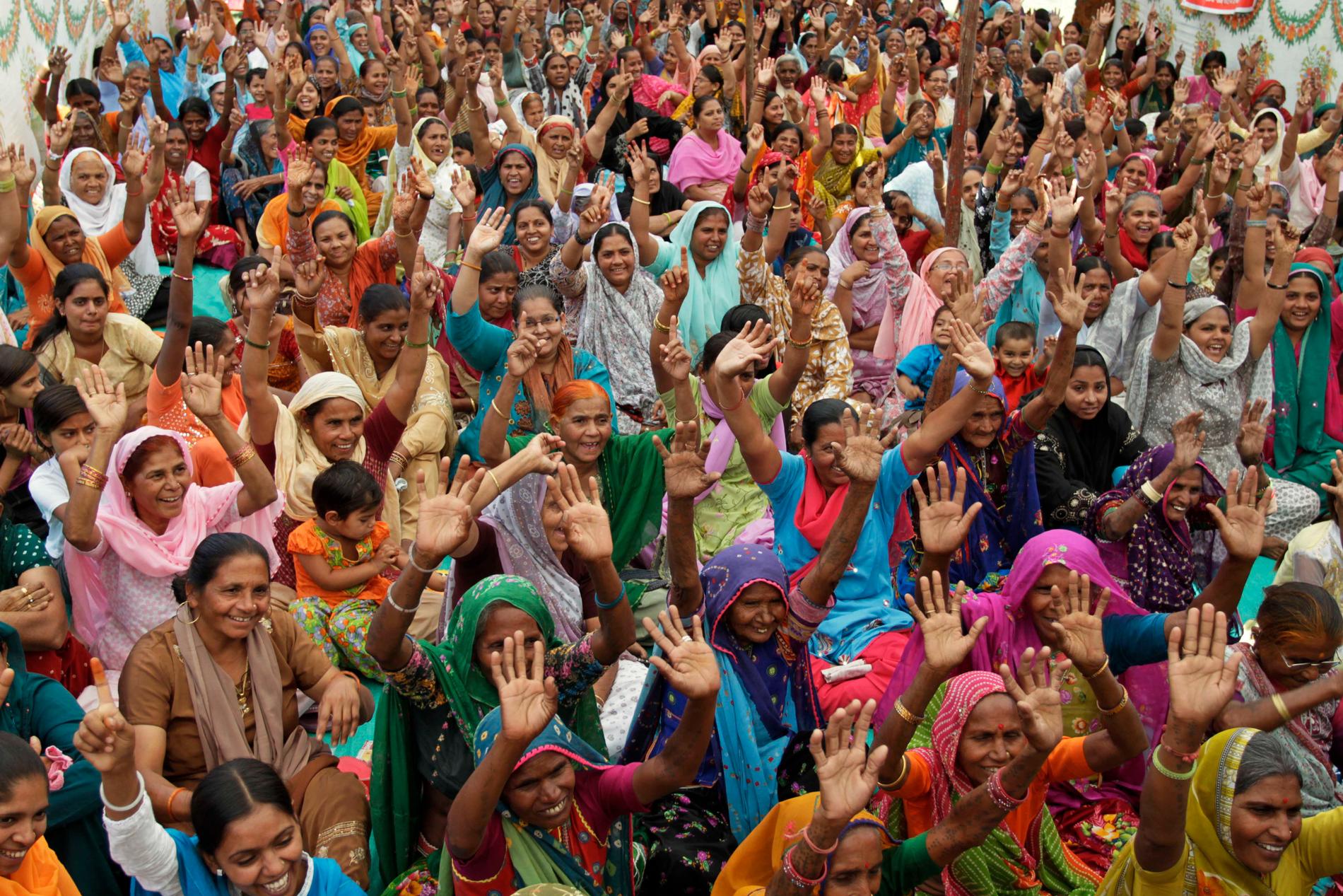 Kvinnor lyfter sina händer under en demonstration på internationella kvinnodagen i indiska Ahmadabad, den 8 mars 2011.
