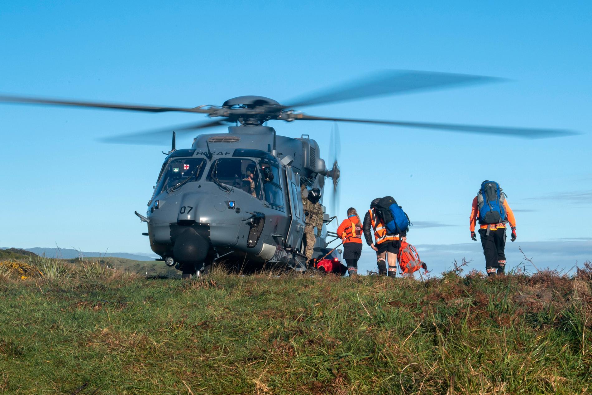 Räddningsarbetare går ombord en helikopter som användes i sökarbetet efter de två försvunna vandrarna.