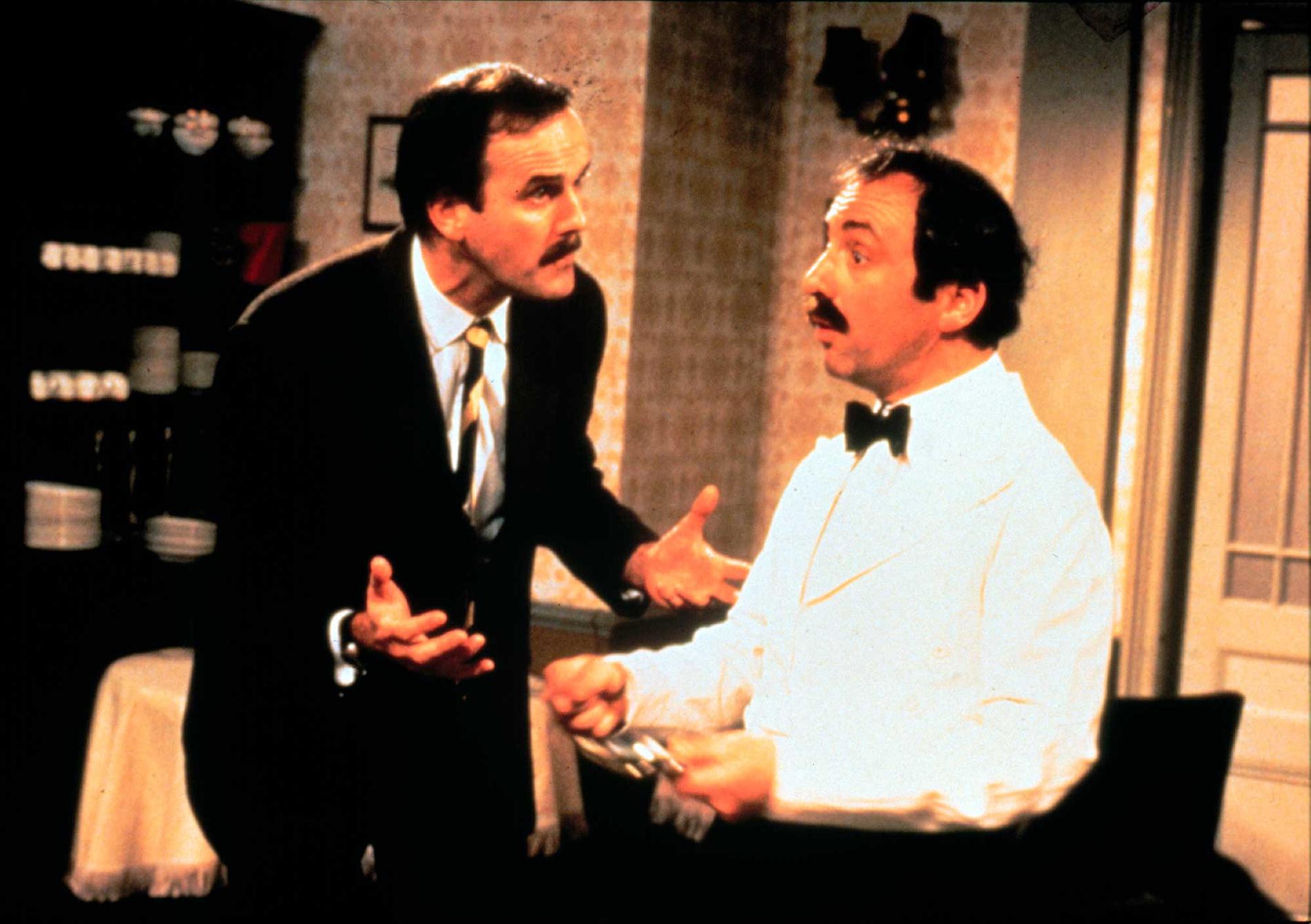 John Cleese som Basil och Andrew Sachs som Manuel i ”Pang i bygget”.