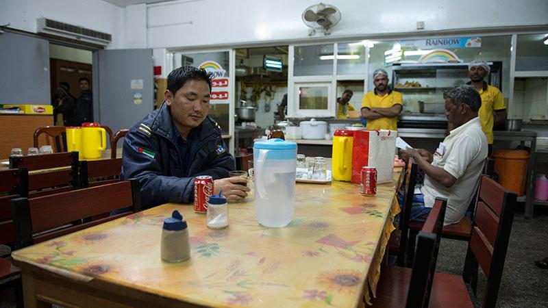 Binod köper en läsk på en restaurang efter sin standardarbetsdag på 13 timmar.
