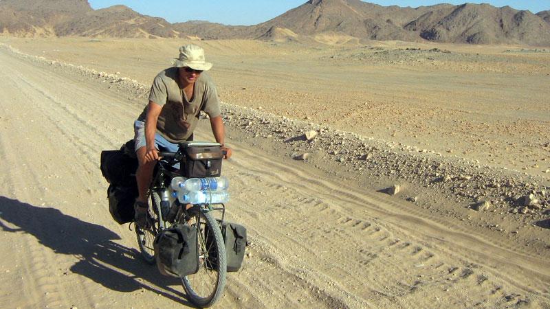 Lars Bengtsson trampar på i Saharas sand. Hans cykel är specialbyggd. Den nuvarande cykeln är hans andra, den första blev stulen  – hemma i Falköping av alla ställen.