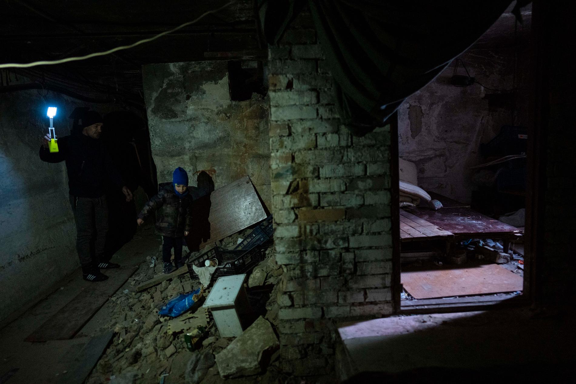 En pappa och hans son i källaren där de var bodde under ockupationen i Butja. 
