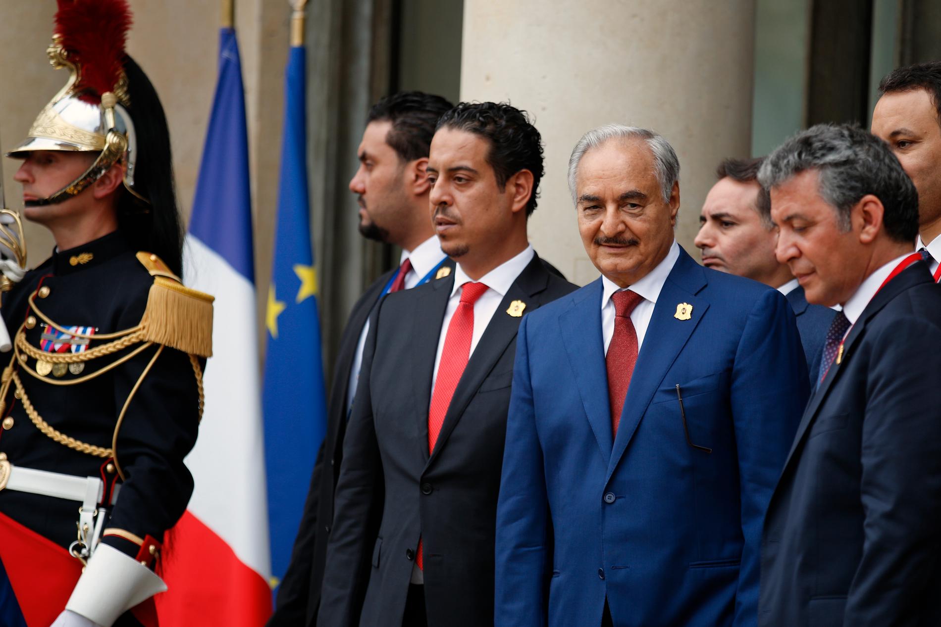 Den östlibyske krigsherren Khalifa Haftar (i blå kostym) efter ett möte i Paris i maj 2018. Arkivbild.