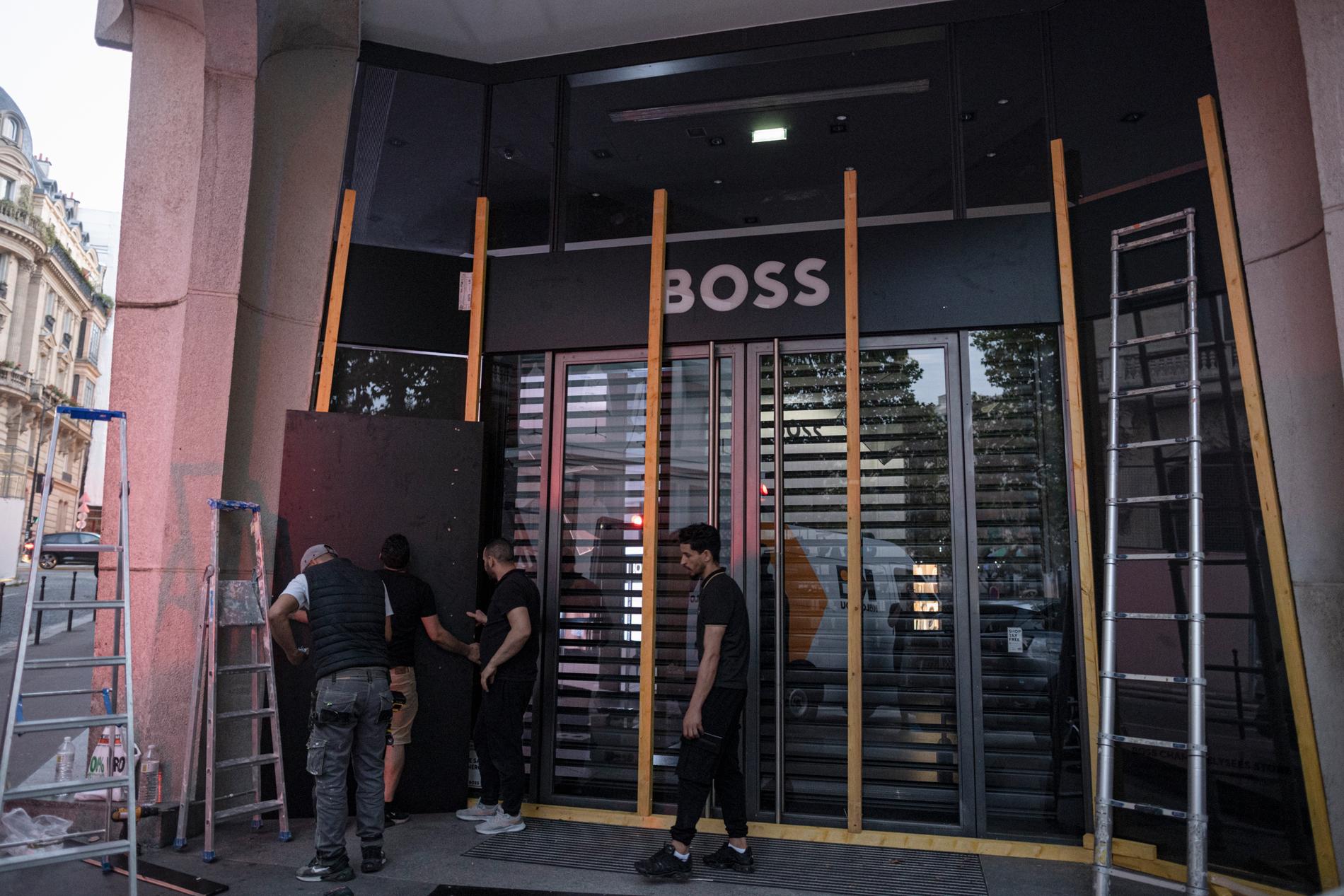 Många försökte skydda sina butiker inför upploppen, som denna Boss-butik i Paris.