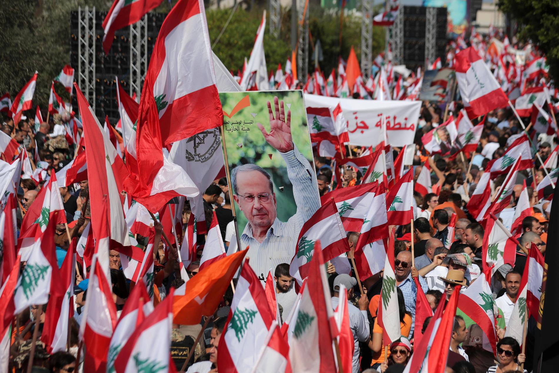 Anhängare till Libanons president Michel Aoun bar bilder av honom vid en stöddemonstration utanför presidentpalatset i Beirut på söndagen.