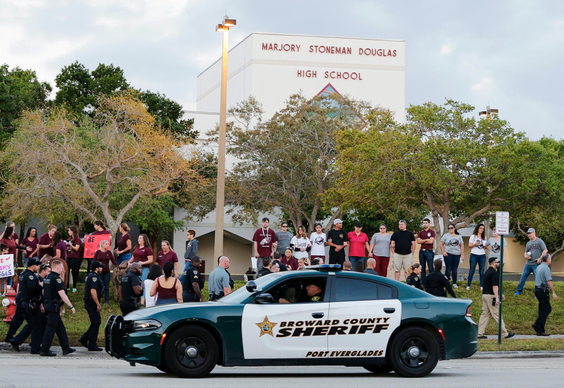 En polisbil kör förbi skolan i Parkland, Florida, när eleverna återvänder efter skolskjutningen. Arkivbild.