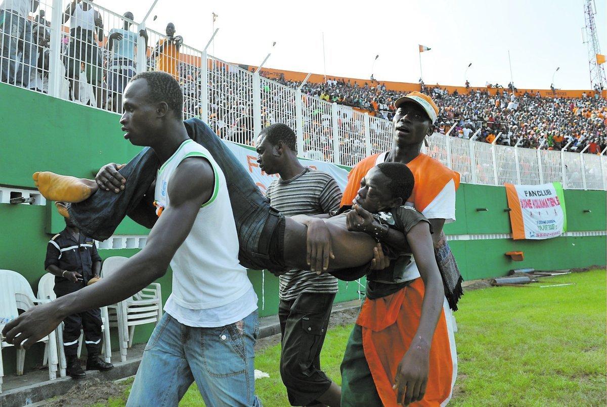 KATASTROFEN SKAKAR Här förs en av många skadade iväg från arenan i Abidjan bort. Vid läktarkatastrofen dog 19 personer.
