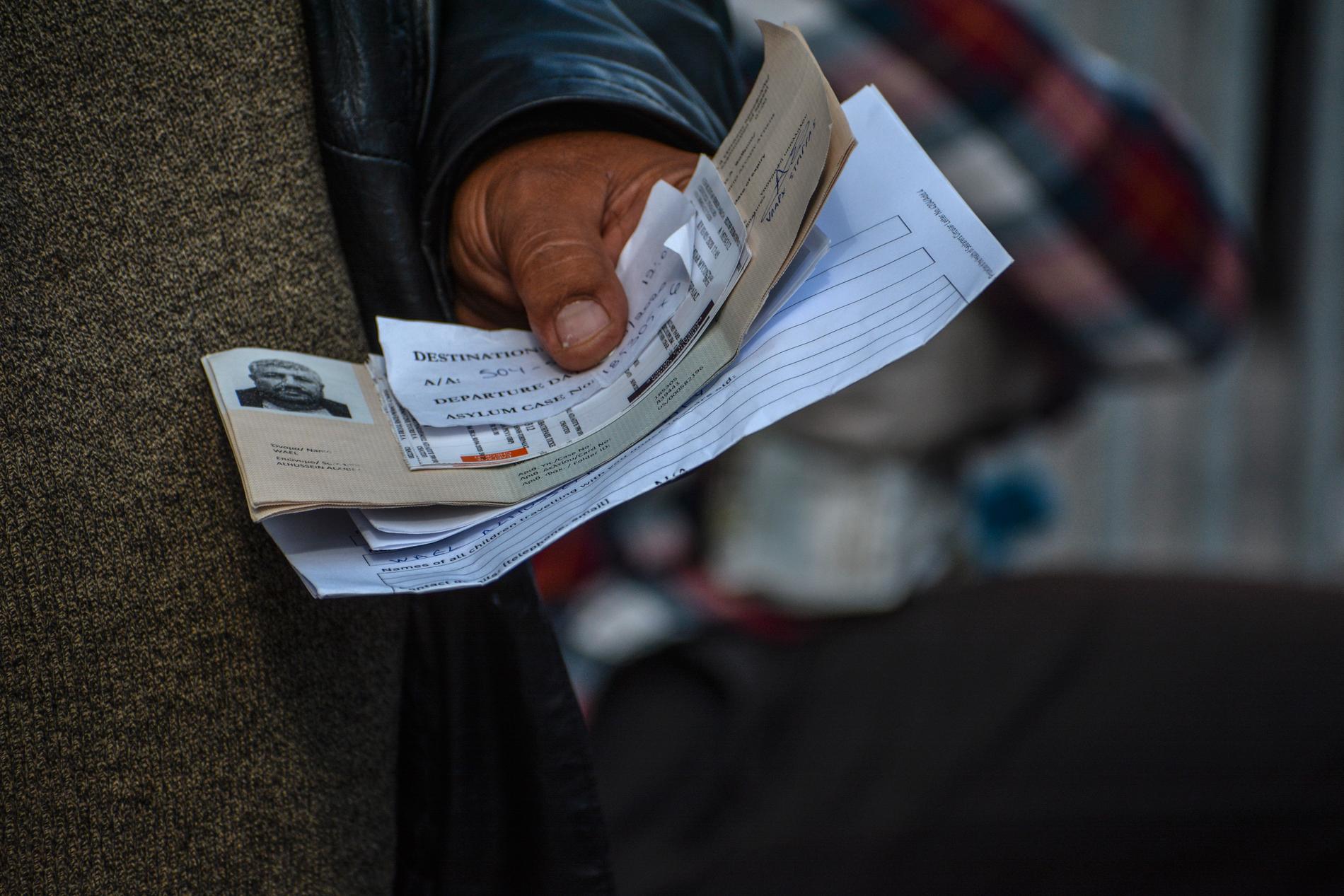 En man håller fram sina dokument för att få resa från ön Lesbos till hamnstaden Piraeus på fastlandet. Arkivbild.