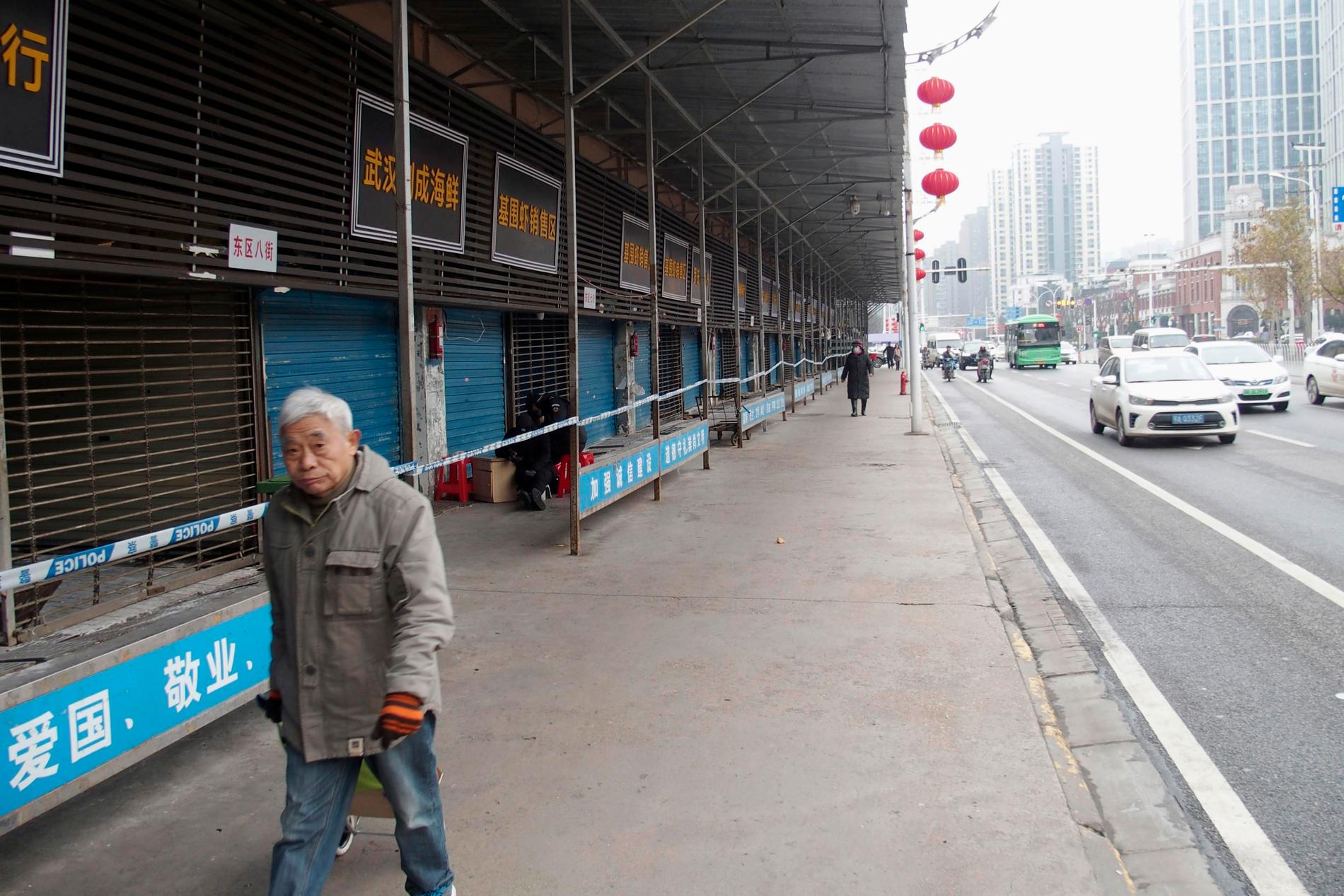 En man passerar den igenbommade marknaden i Wuhan i Kina, där utbrottet av det sarsliknande viruset tros ha börjat.