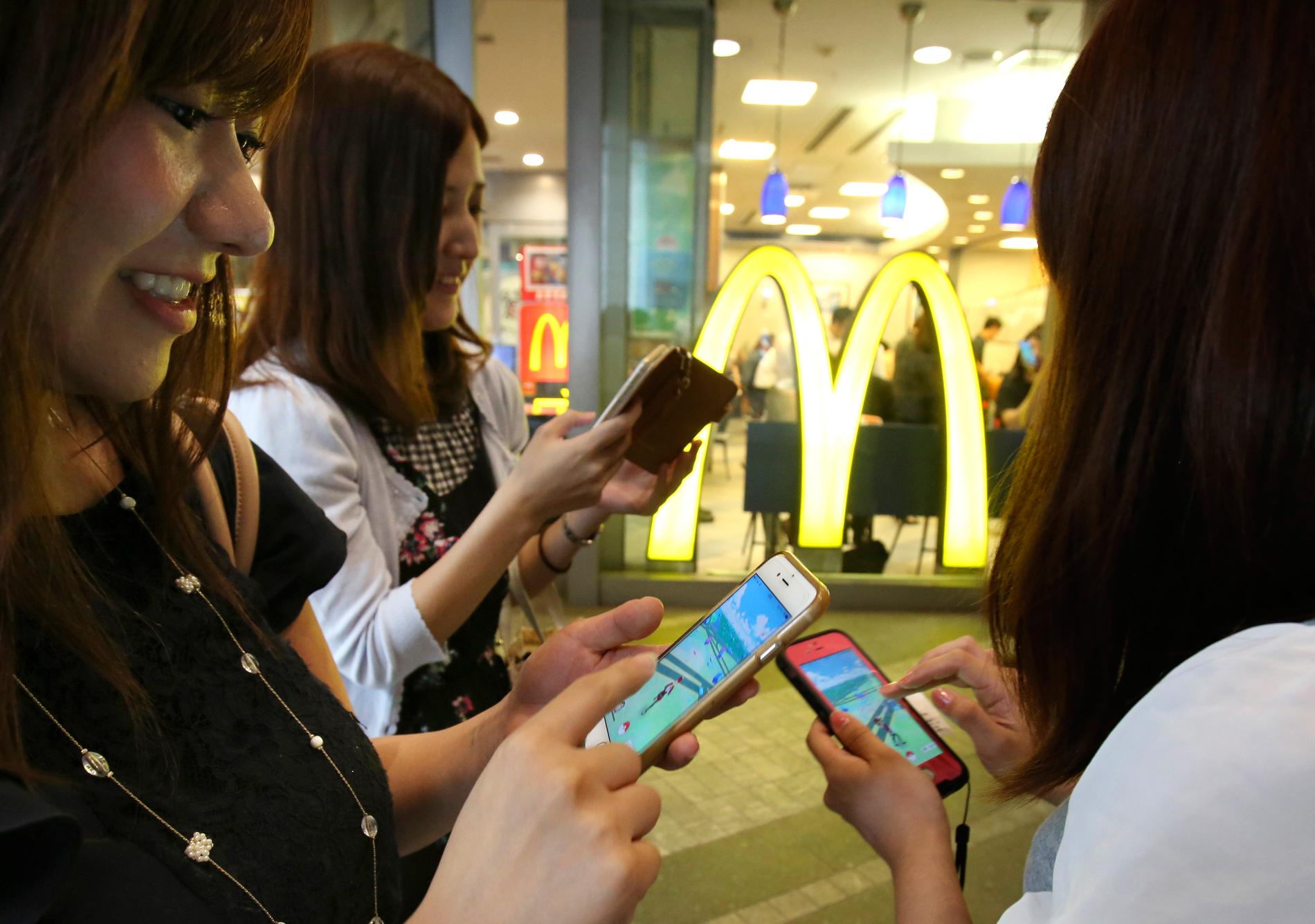 Några kvinnor spelar Pokémon Go utanför McDonald's i Tokyo fredagen den 22 juli.