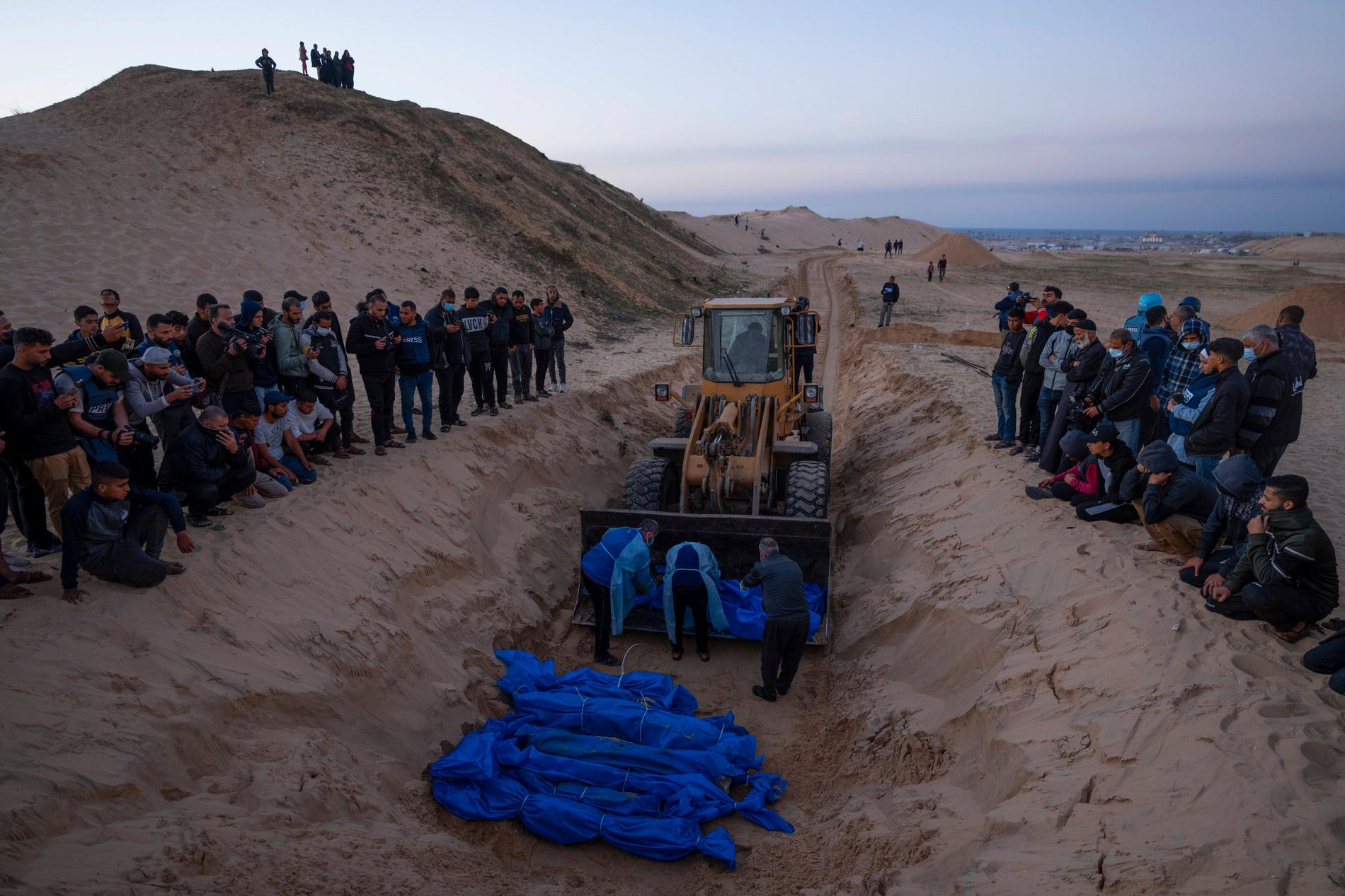 En bulldozer med döda människor i skopan vid en massbegravning i Rafah i december.