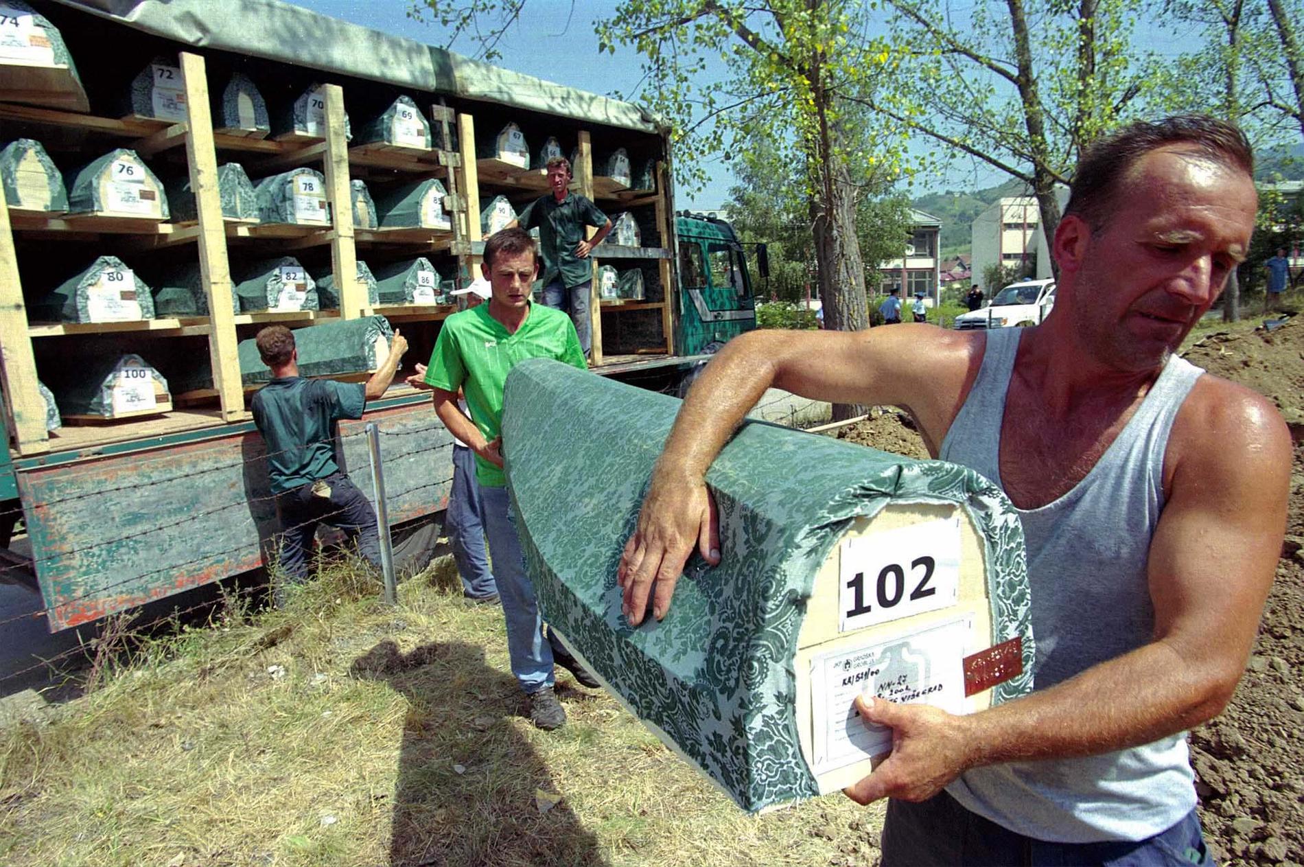 Arbetare bär en kista med en oidentifierad bosnisk muslim under en begravning i Visegrad, 120 km öster om Sarajevo, 5 augusti 2001. Hundratals har samlats till återbegravningen av 152 muslimer som dödades under kriget 1992–1995 och slängdes i massgravar. 