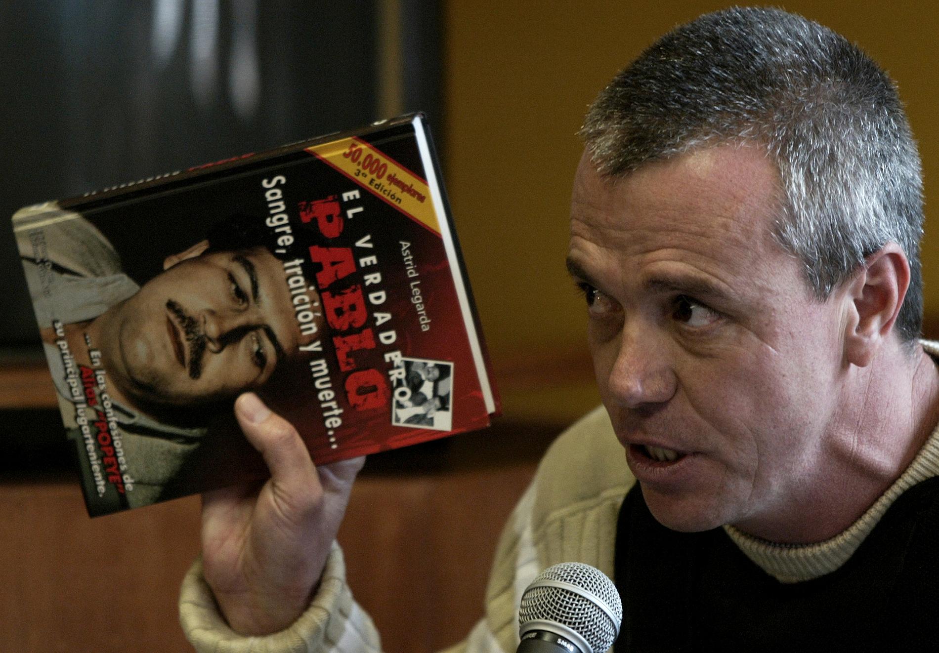 Yrkesmördaren Jhon Jairo Velasquez, här med en bok om sin forne chef Pablo Escobar, har gått bort i cancer. Arkivbild.