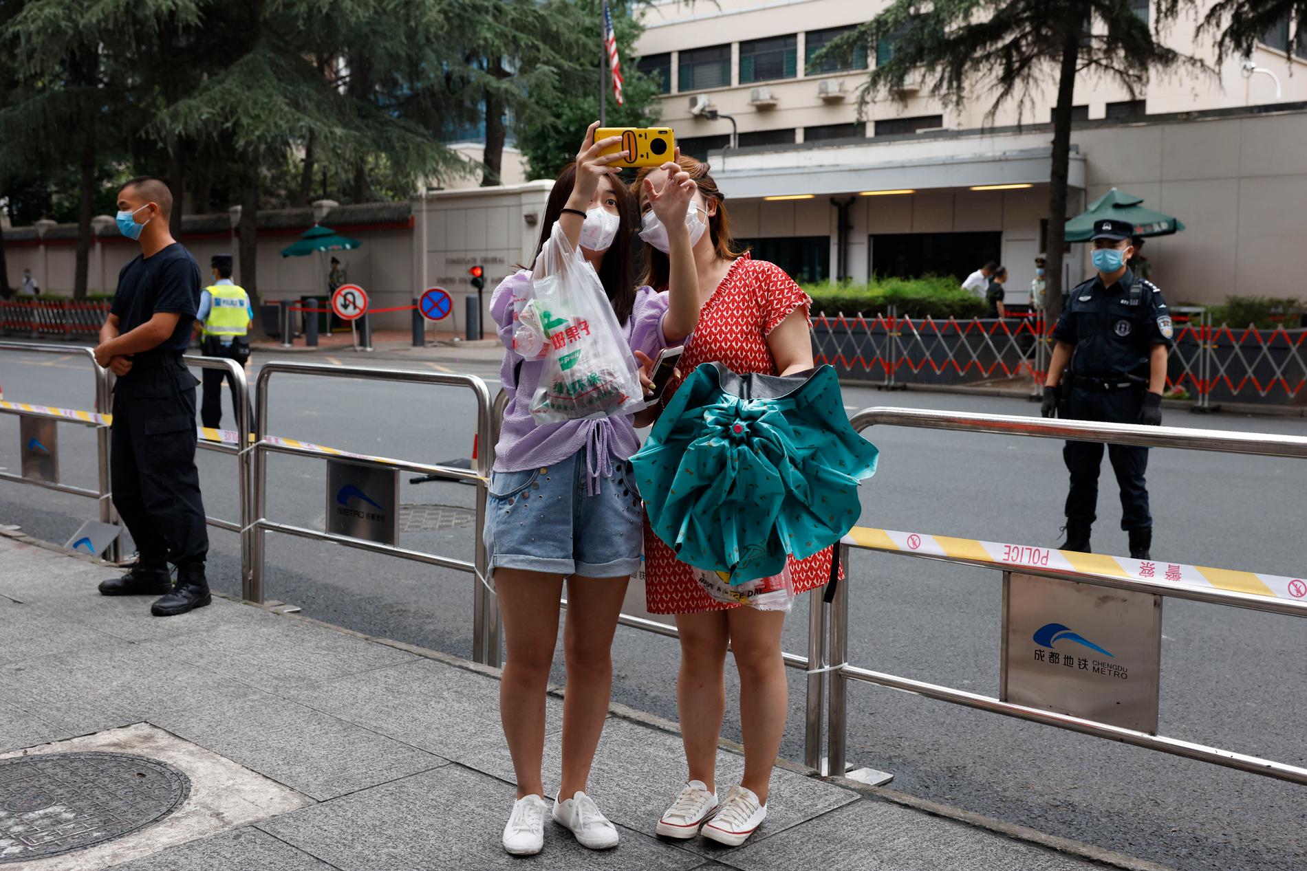 Två kvinnor tar en selfie utanför konsulatet i Chengdu.