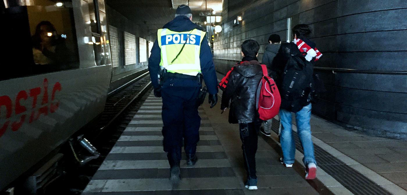 Flyktingar ledsagas av polis i Malmö.
