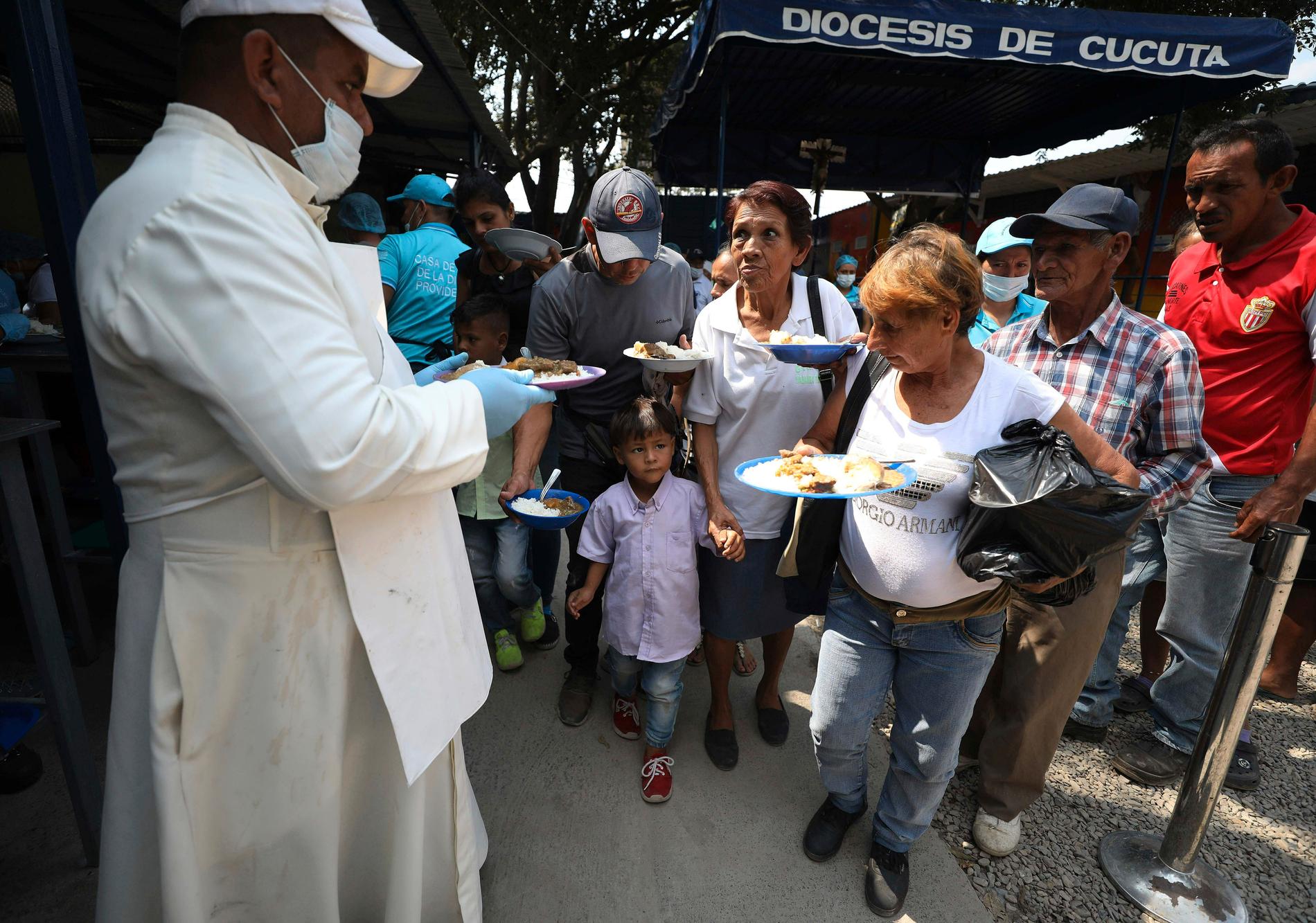 En präst vid en katolsk kyrka delar ut mat till venezuelanska migranter i La Parada, nära Cúcuta, Colombia. Arkivbild.