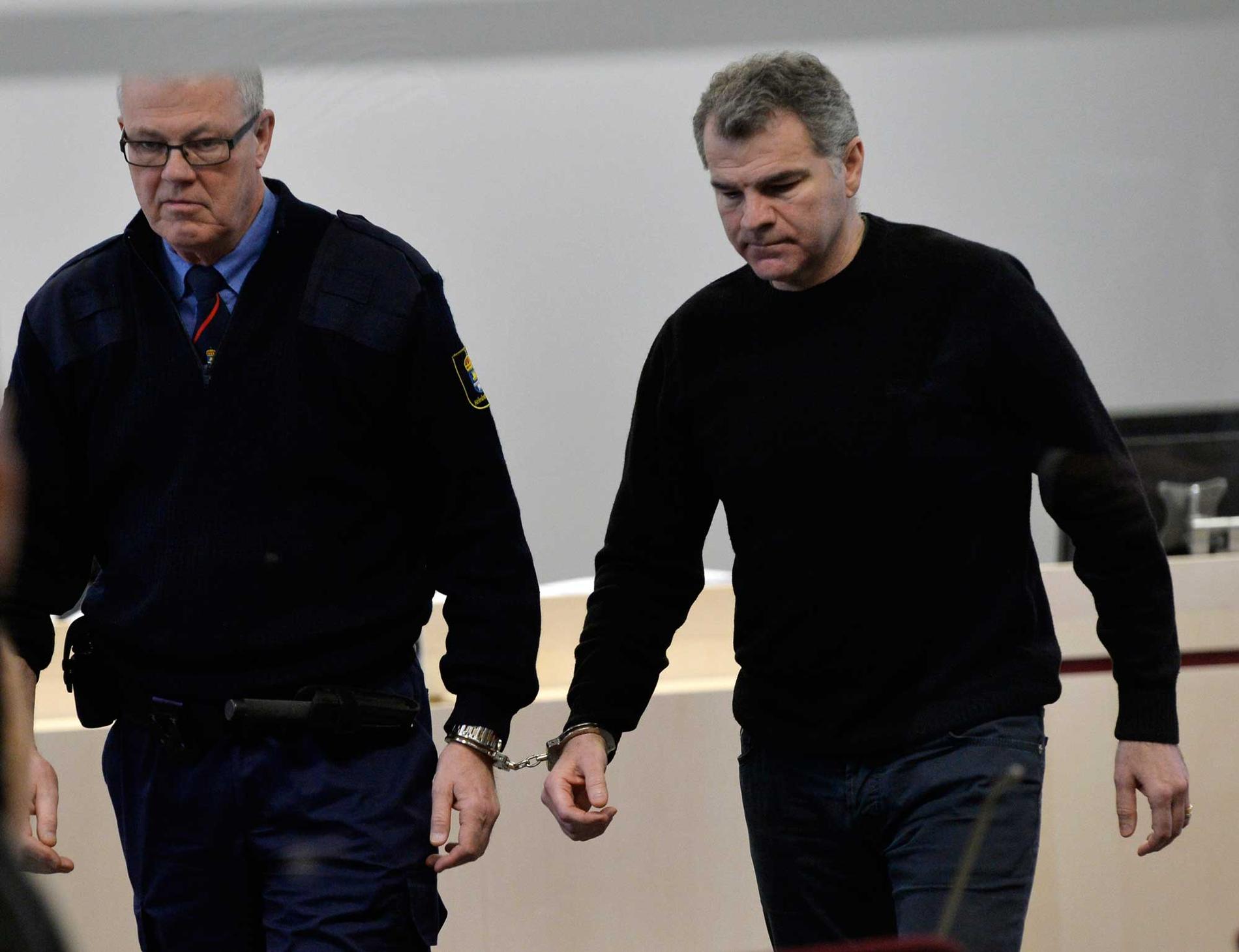 52-åringen (till höger) förs ut ur salen under rättegången mot honom.