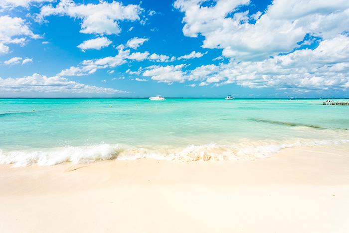 Blått vatten och vit sand lockar turister till Cancun. 
