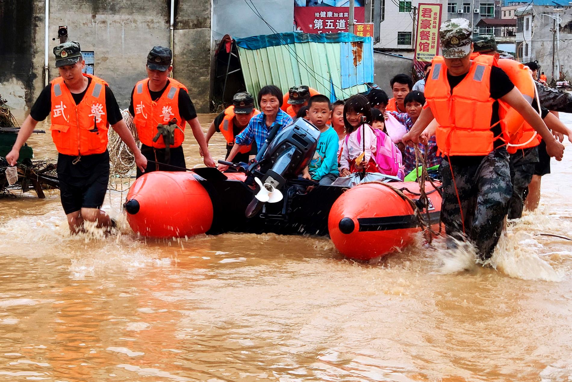 Kinesisk paramilitär polis evakuerar människor efter översvämningar i Heyuan i södra Kina 10 juni 2019. Arkivbild.