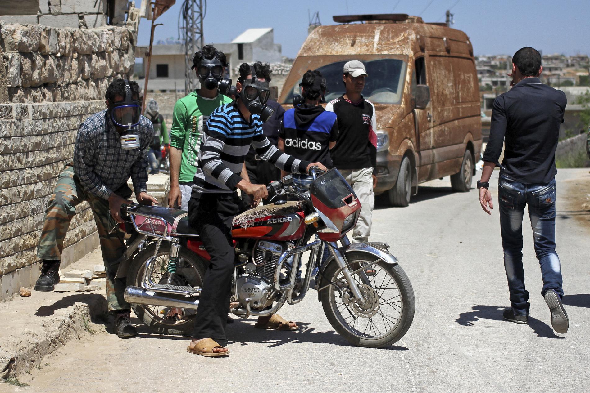 Civila bär gasmask i Kansafra. Rebeller hävdar att regeringssidan släppt klorgas i området.