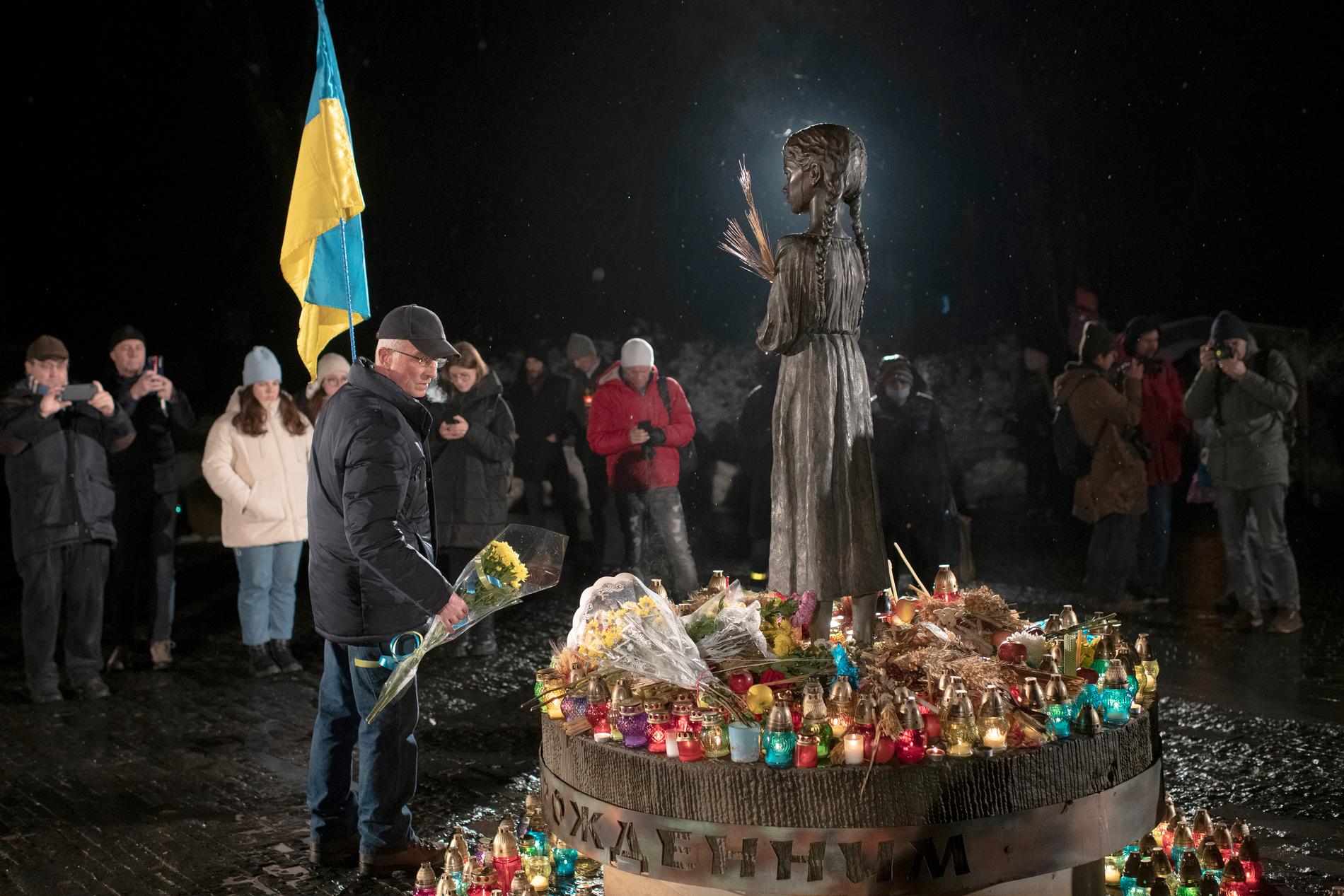 Folk tänder ljus och lägger ner blommor vid monumentet över offren för Holodomor i Kiev under lördagen.
