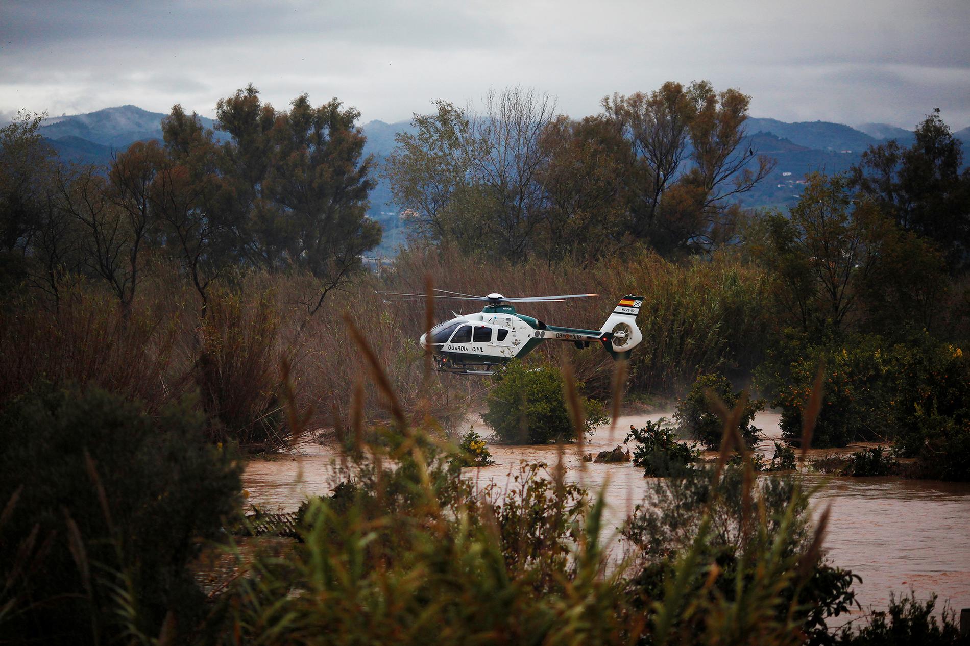 En helikopter från spanska civilgardet flyger över översvämmade fält i Cartema.