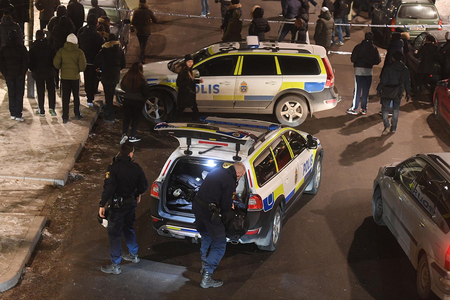 Polis och folksamling vid mordplatsen i Rinkeby.