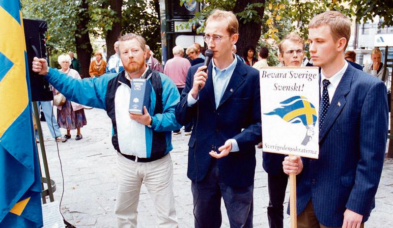 Sverigedemokrater håller 1998 möte i Brunnsparken i Göteborg. Då med den gamla partisymbolen i handen, den fascistiska facklan, och skinnskallarnas slagord.