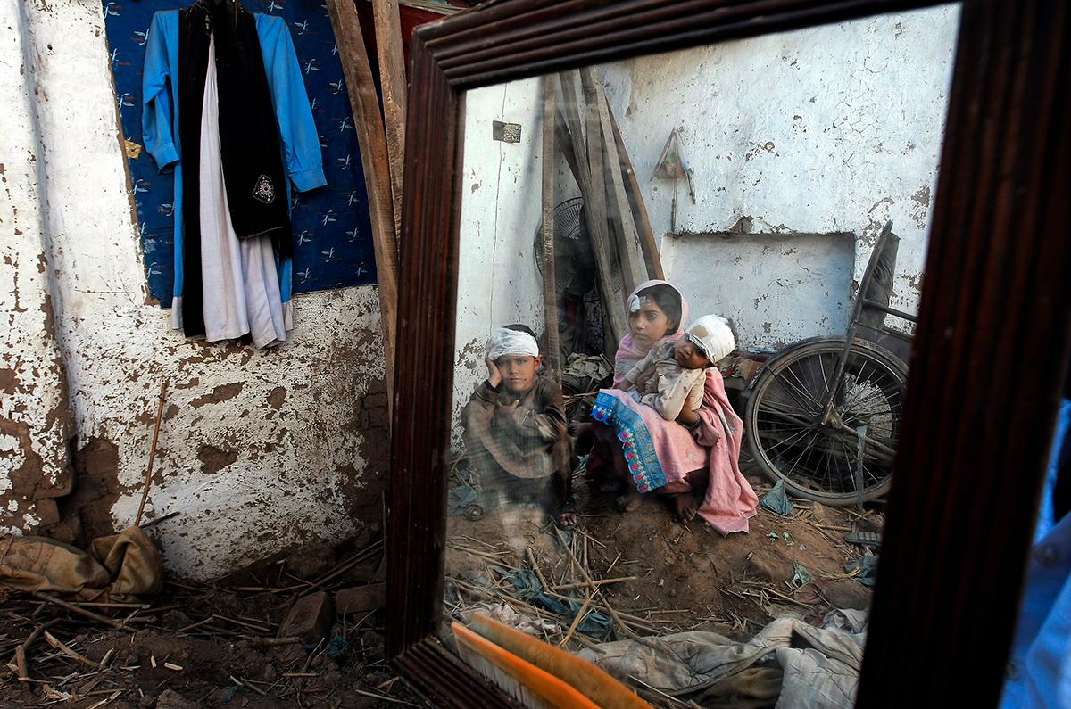 Peshawar, Pakistan: Pakistanska barn sitter utanför sitt förstörda hem efter jordbävningen som drabbade landet och grannlandet Afghanistan. Dödssiffran uppges fortfarande stiga och flera hundra ska ha omkommit i katastrofen.