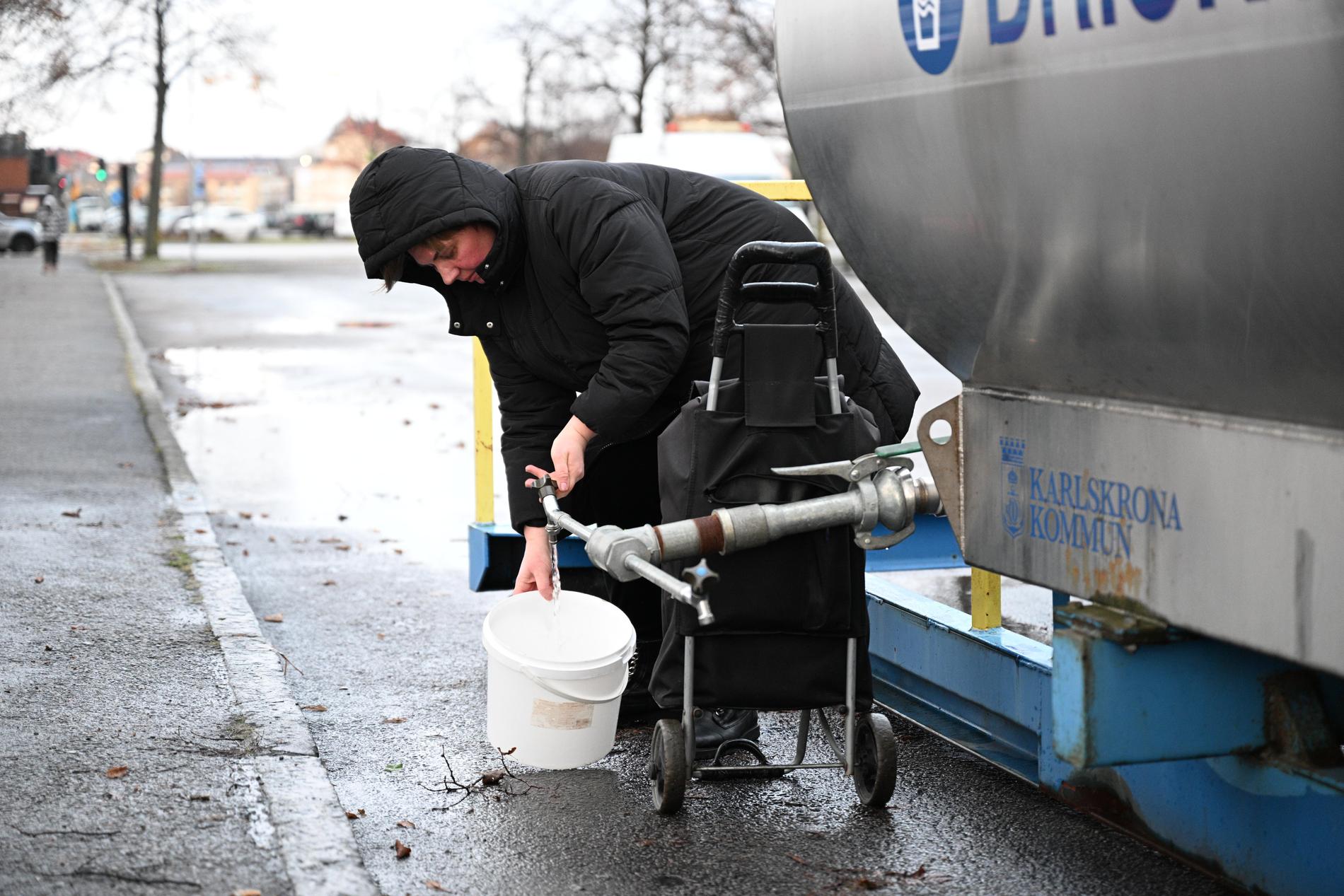 Nadja Vasileva hämtar vatten från en vattentank på busstorget efter vattenläcka i centrala Karlskrona.