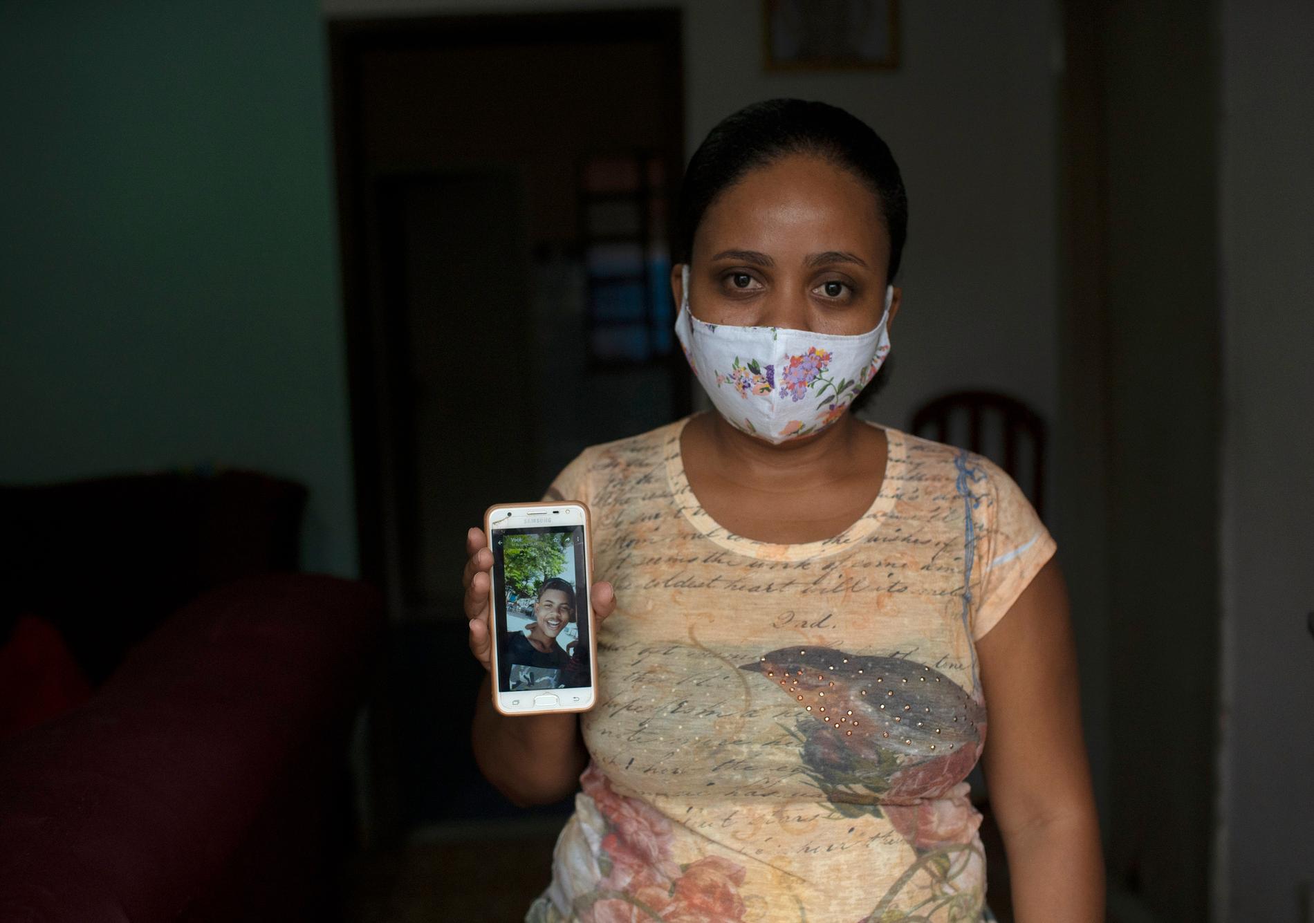 Rafaela Matos, mamma till 14-årige João Pedro Matos Pinto, visar upp en bild på sonen som dog efter att ha blivit skjuten på nära håll i magen i en drogpolisräd.