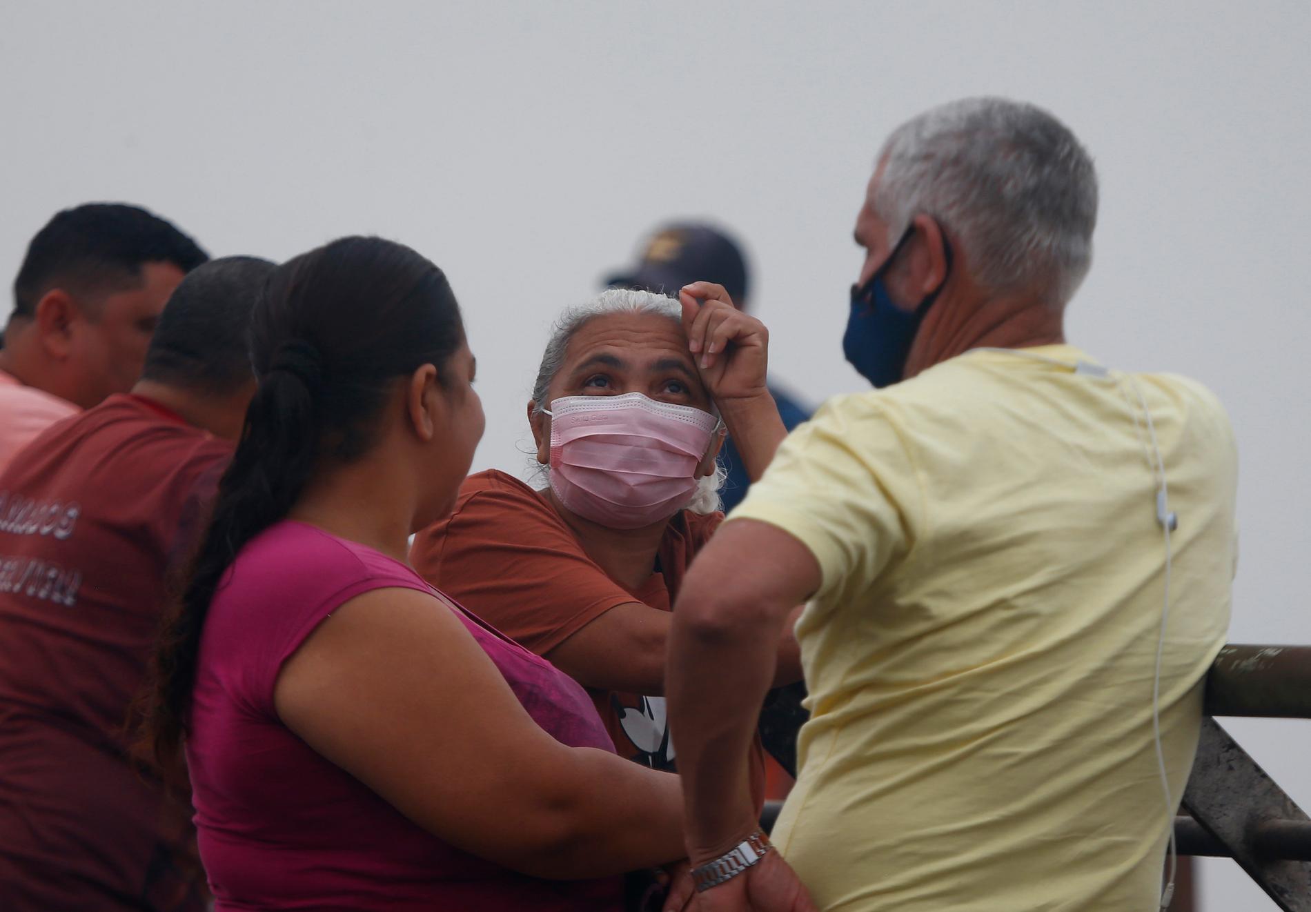 Människor bär masker för att skydda sig mot rök från skogsbränder under en värmebölja, i Brasilien. Bild från 12 oktober.