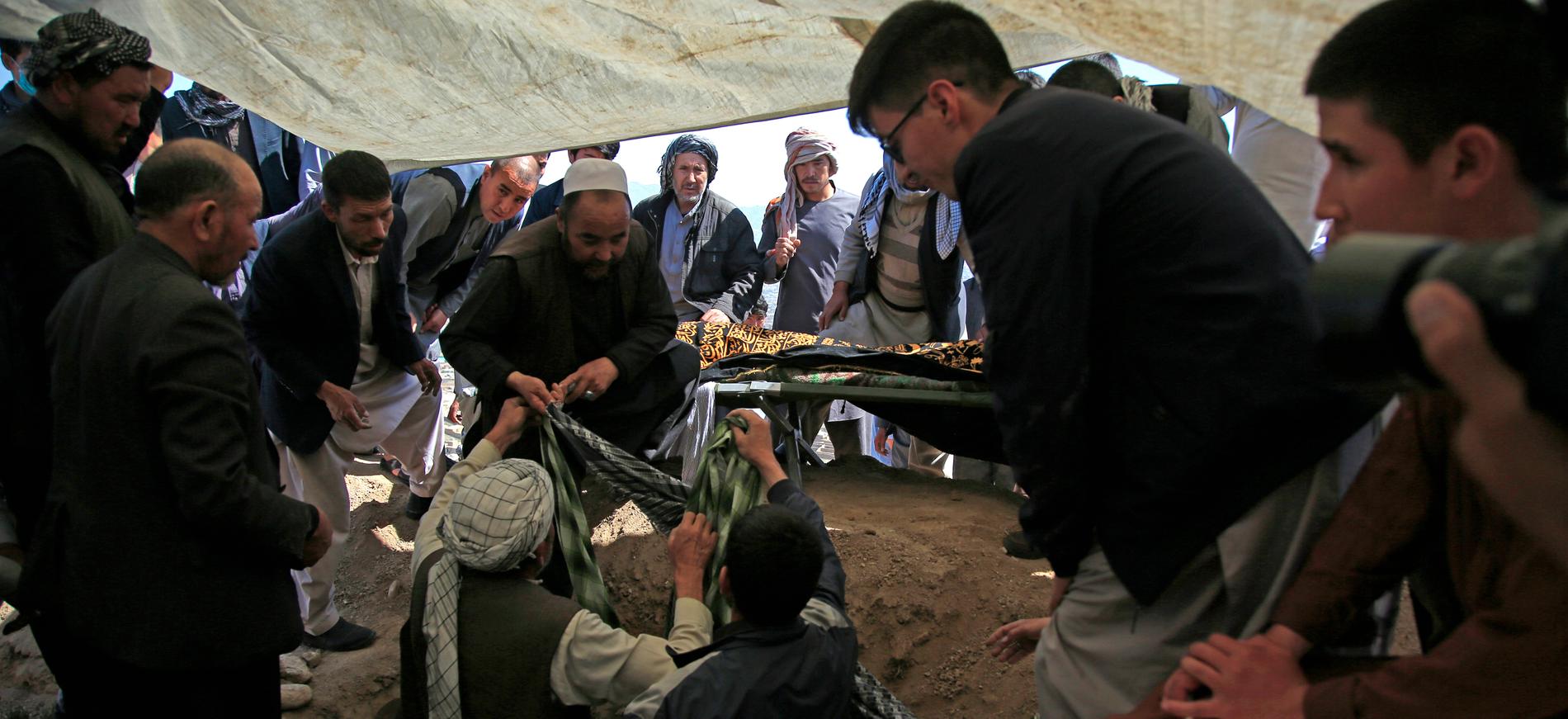 Afghanska män begraver de som dödats i lördagens bombdåd. Landets inrikesministerium har uppgett att flera sprängladdningar detonerade vid ingången till en flickskola. Över 50 personer har dött, många av dem flickor – skolelever mellan 11 och 15 år.