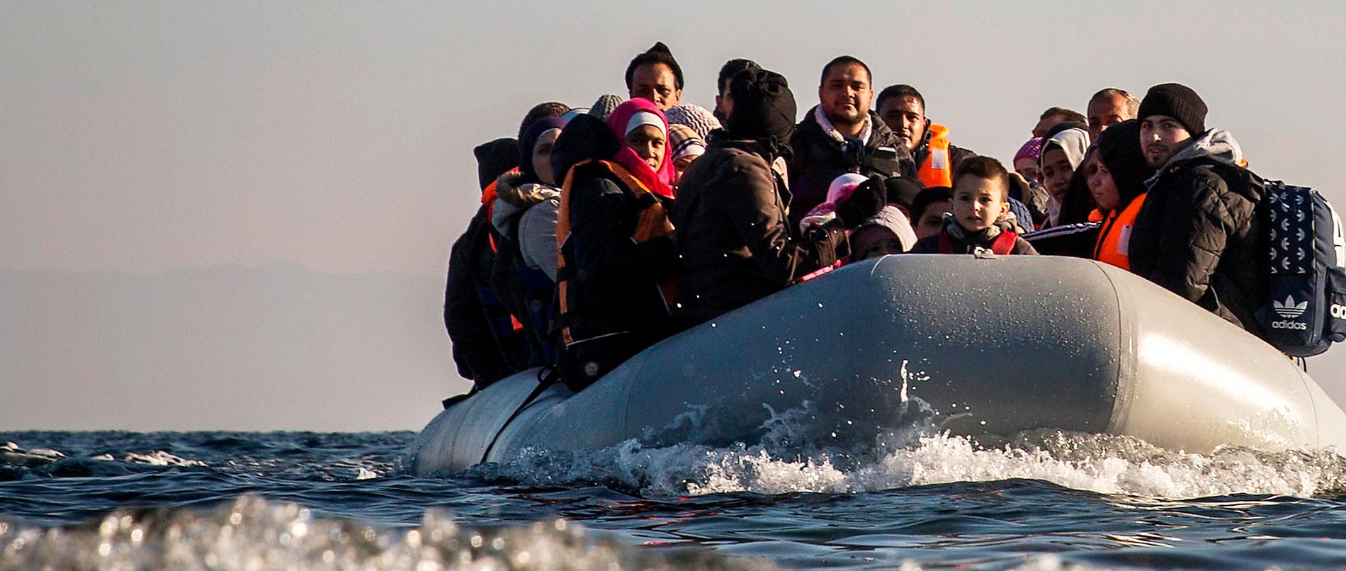 Flyktingar och  migranter anländer  i gummibåt till den grekiska ön  Lesbos.