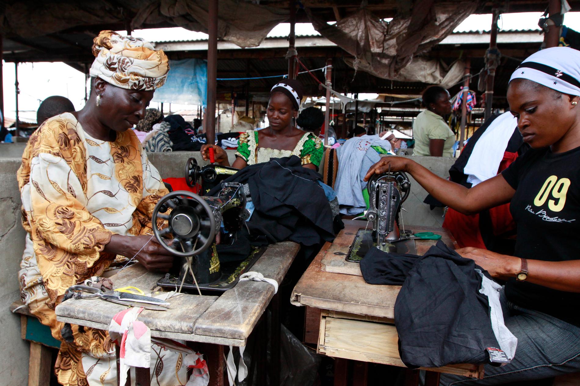 Kvinnor arbetar med lagning av kläder på en marknad i Lagos, Nigeria. Arkivbild.