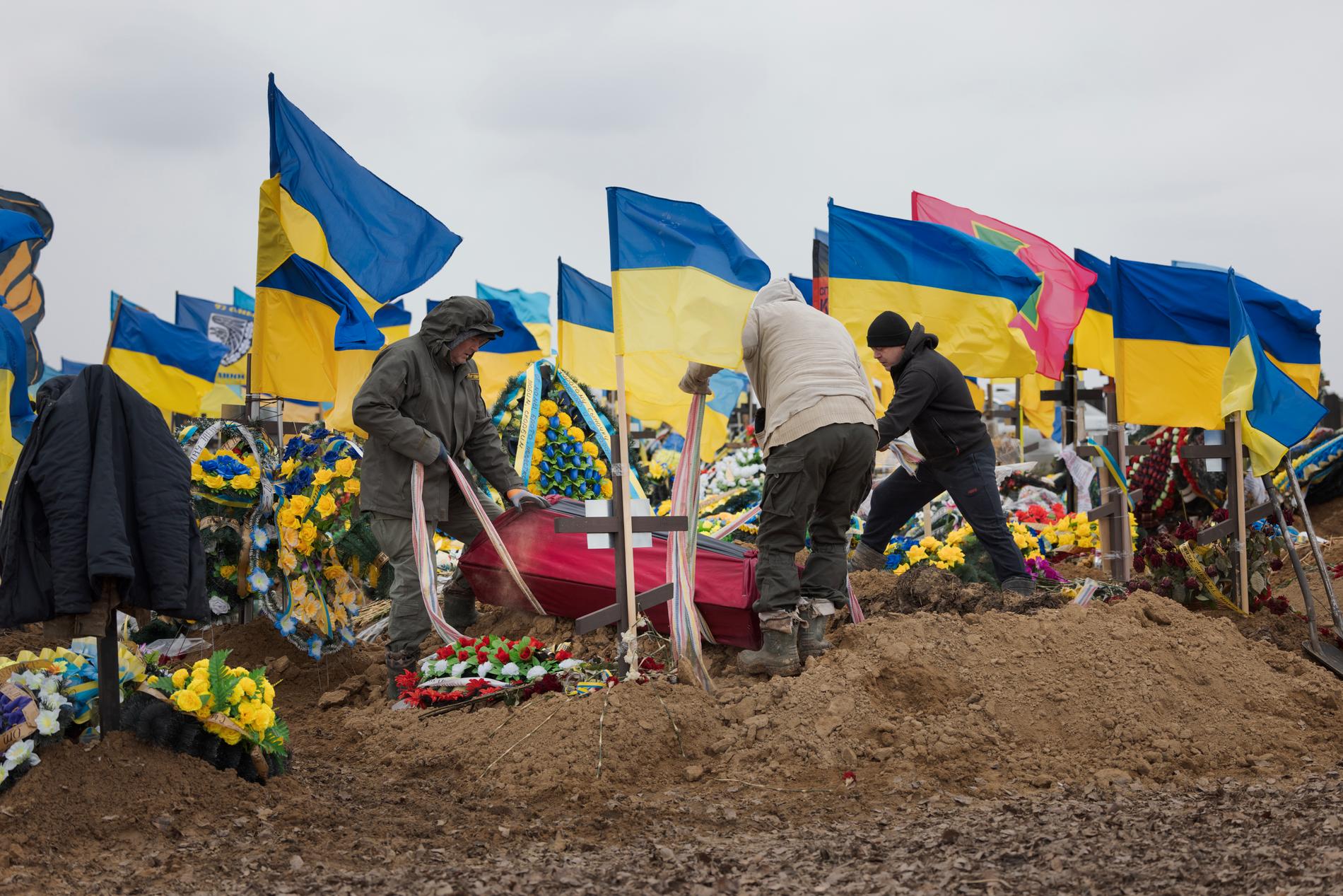 Soldater begravs sida vid sida i nygrävda gravar i Charkiv, Ukraina. 